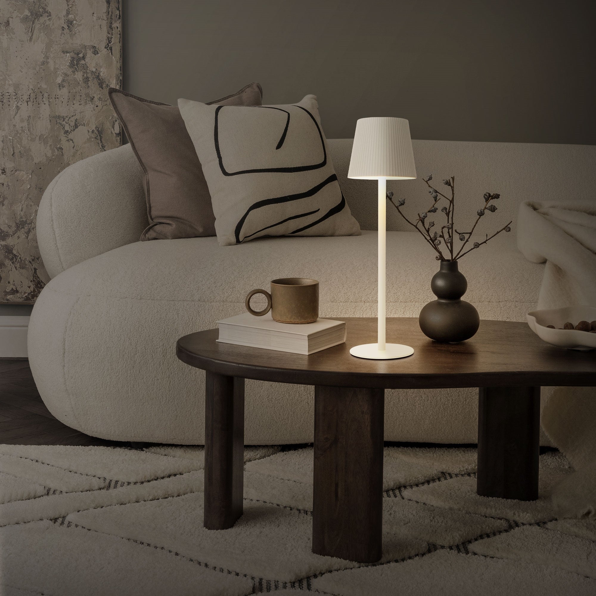 Living room with illuminated lamp, sofa, and table.