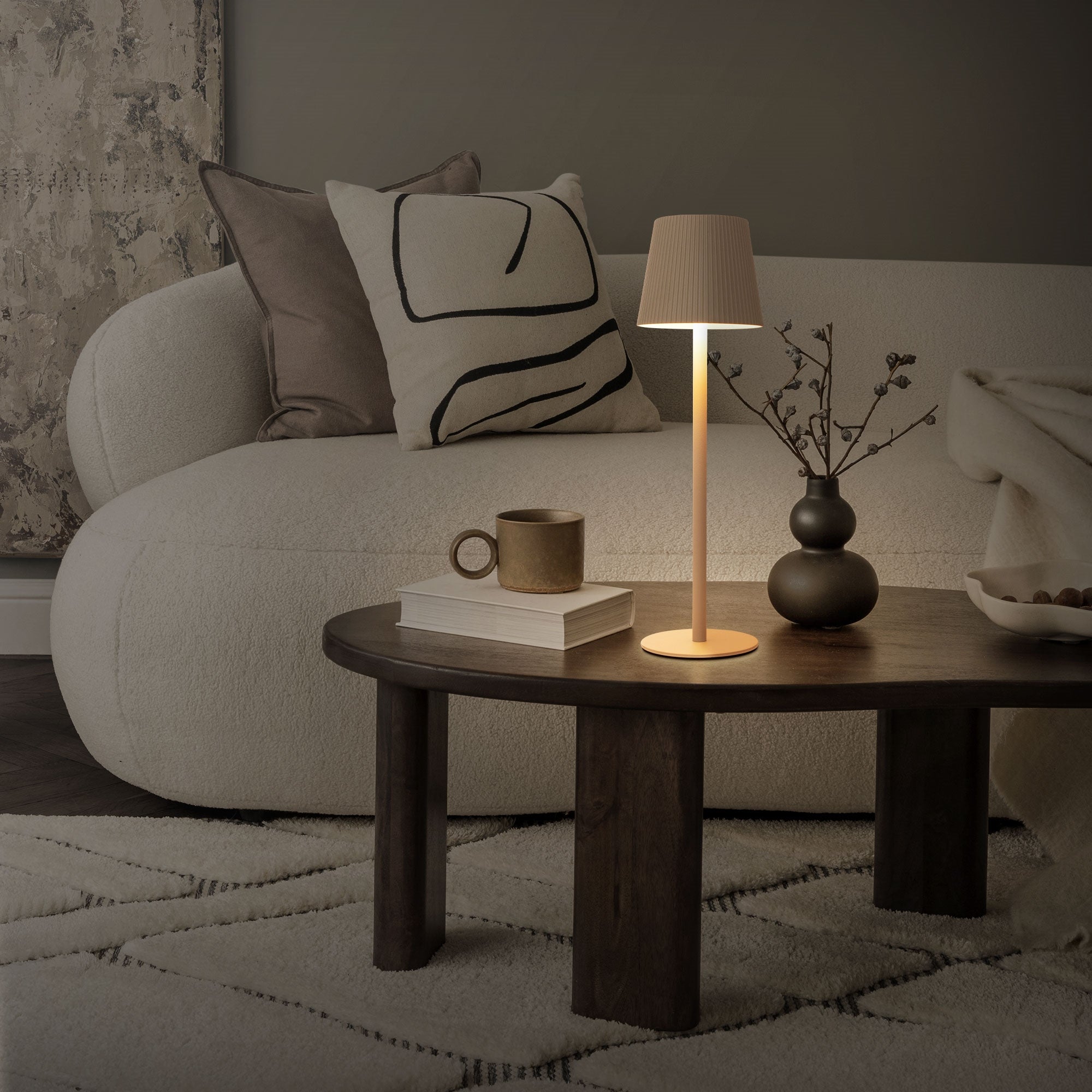 Cozy living room setup with a lamp, a table, and a couch.