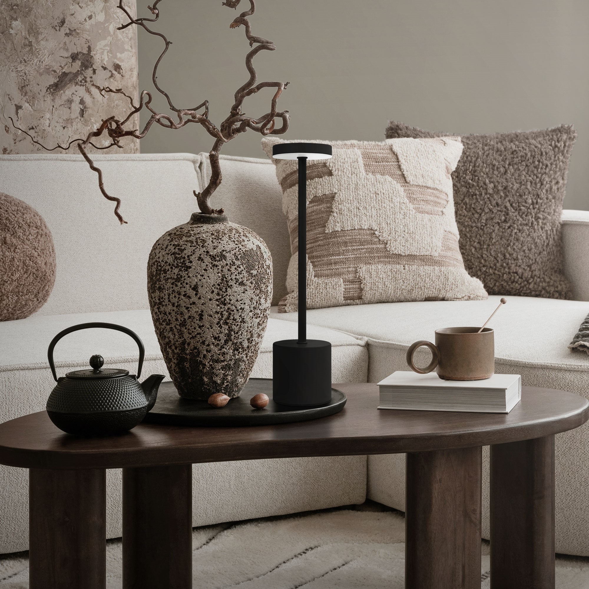 Lampe de table moderne sur une table avec une théière et un vase.