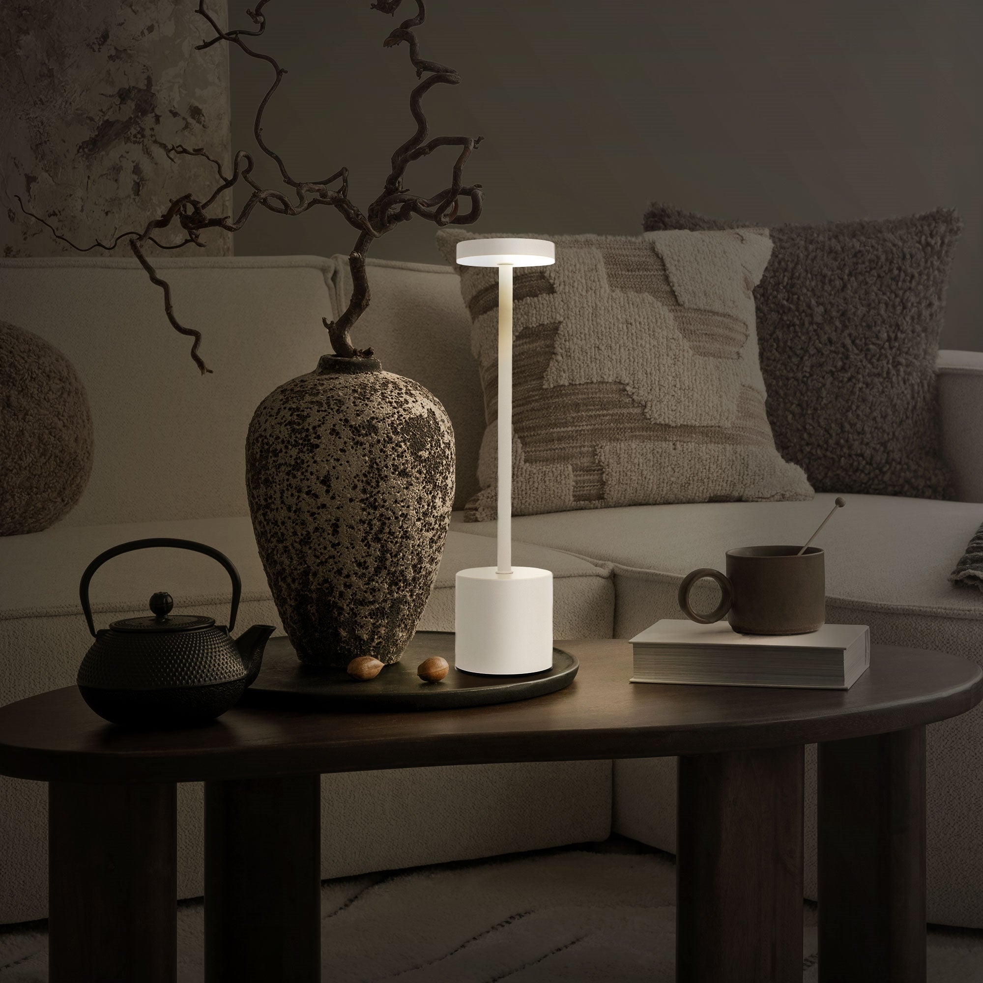 Tischlampe in einem dunklen Raum auf einem Couchtisch mit Dekoration.