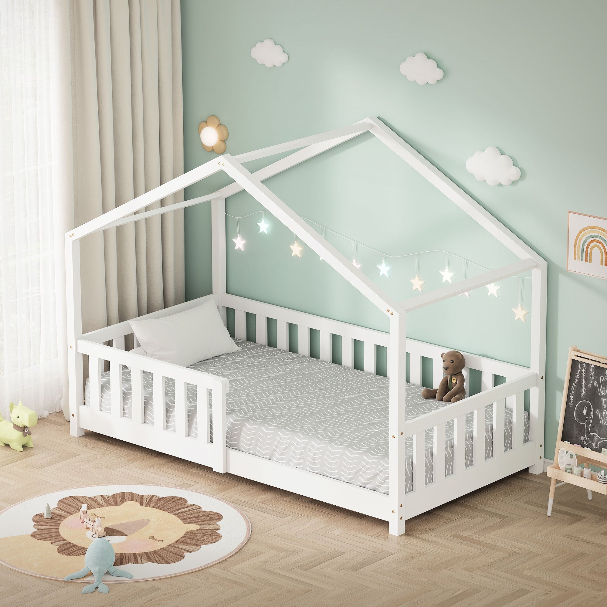 Un lit pour enfant en forme de maison avec des lumières en forme d'étoiles et un ours en peluche sur le matelas.