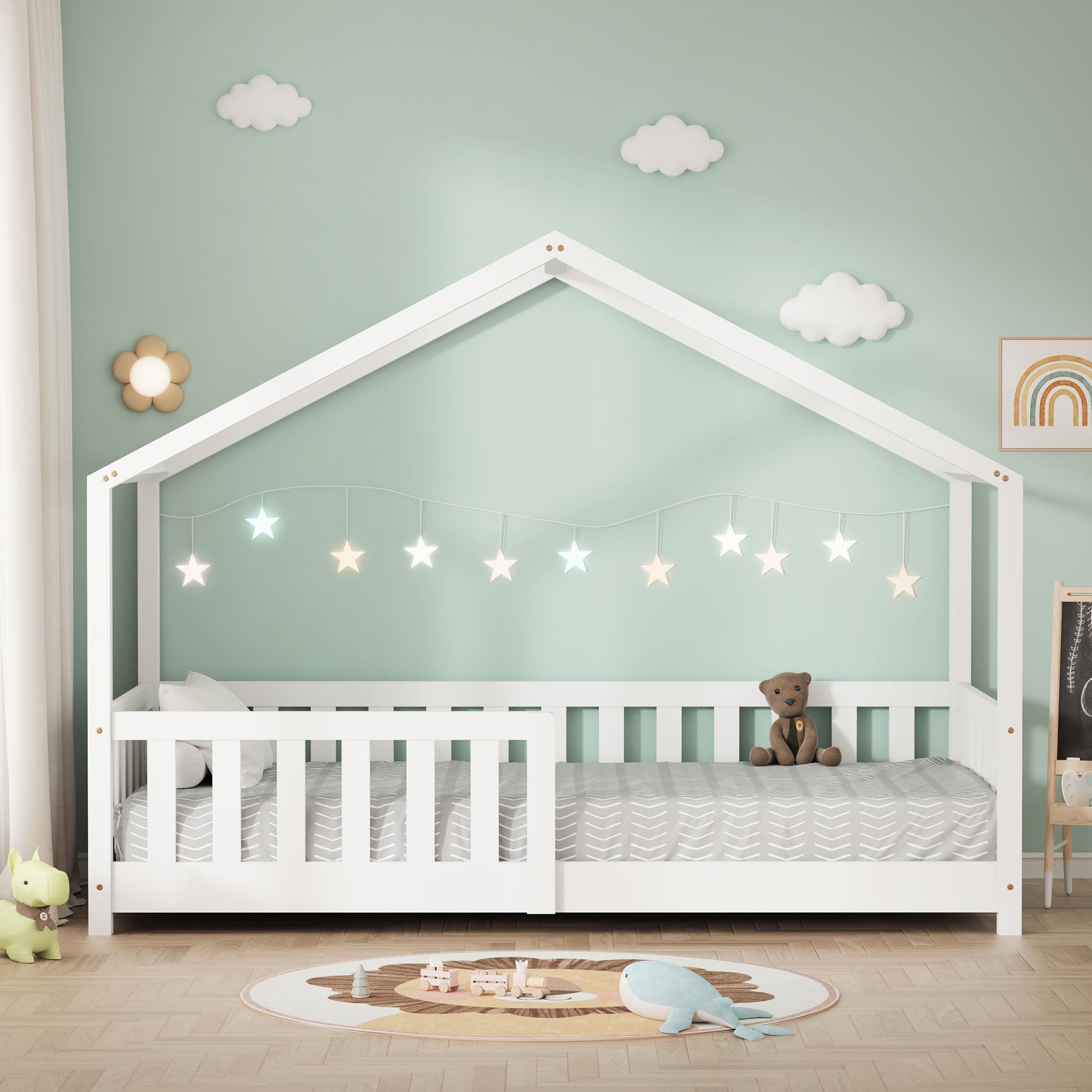 Lit en bois blanc avec guirlande lumineuse et jouets dans la pièce.