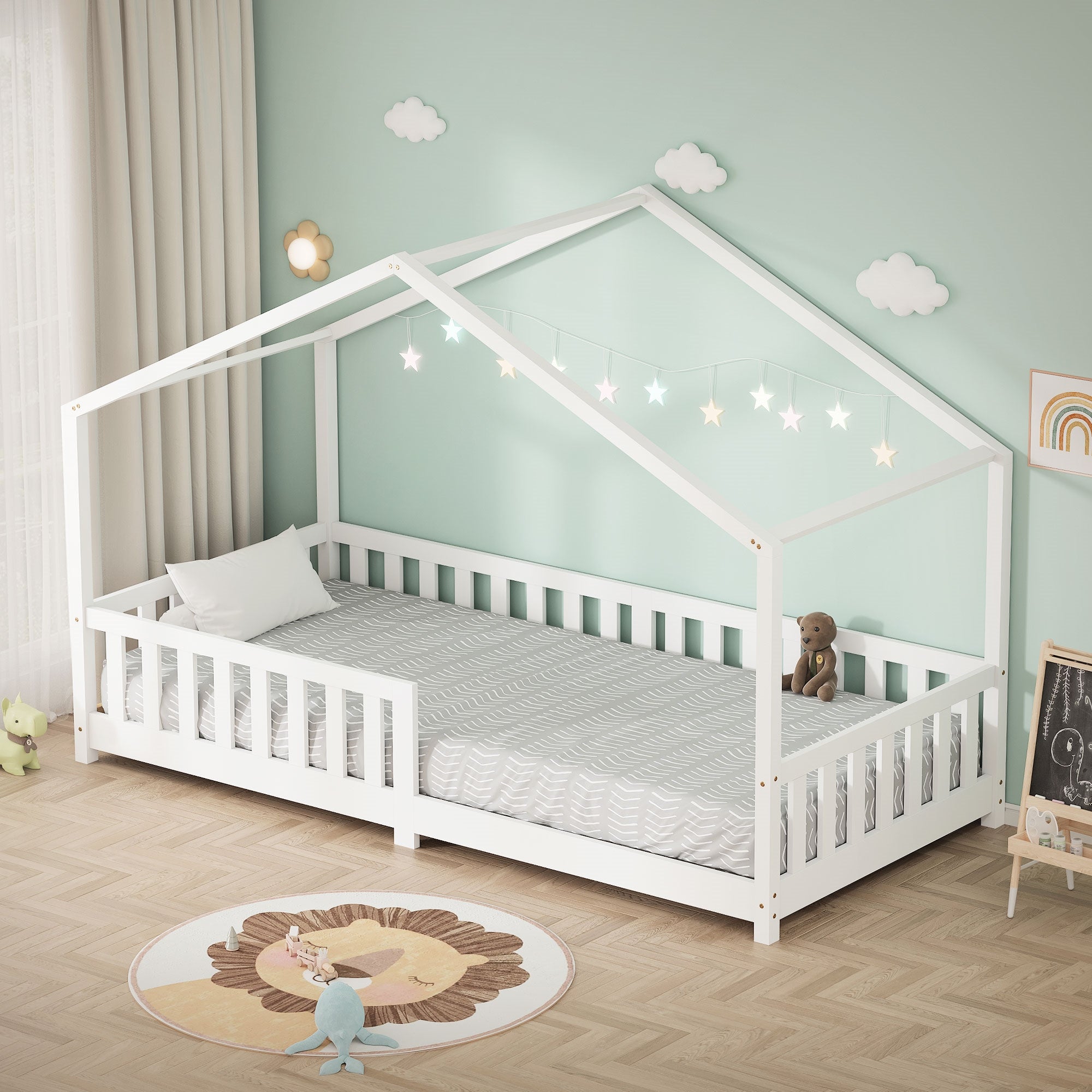 Ein weißes Bett mit Hausdach-Design, umgeben von einer grünen Wand und Dekoration.