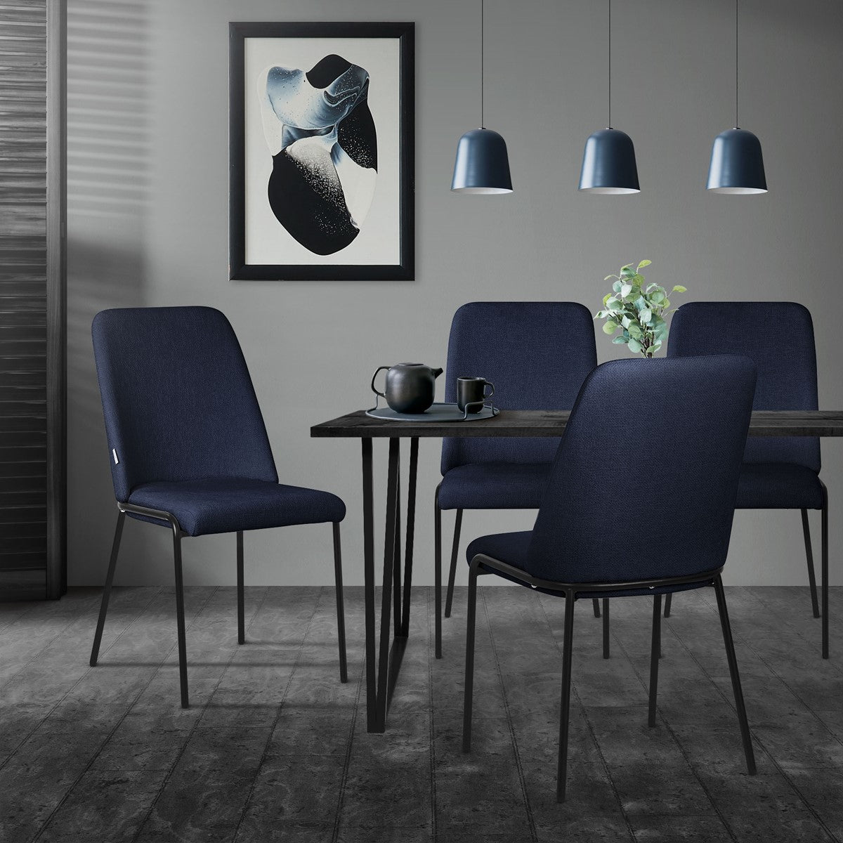 Dining area with four dark blue chairs and a table, decorated with plants.
