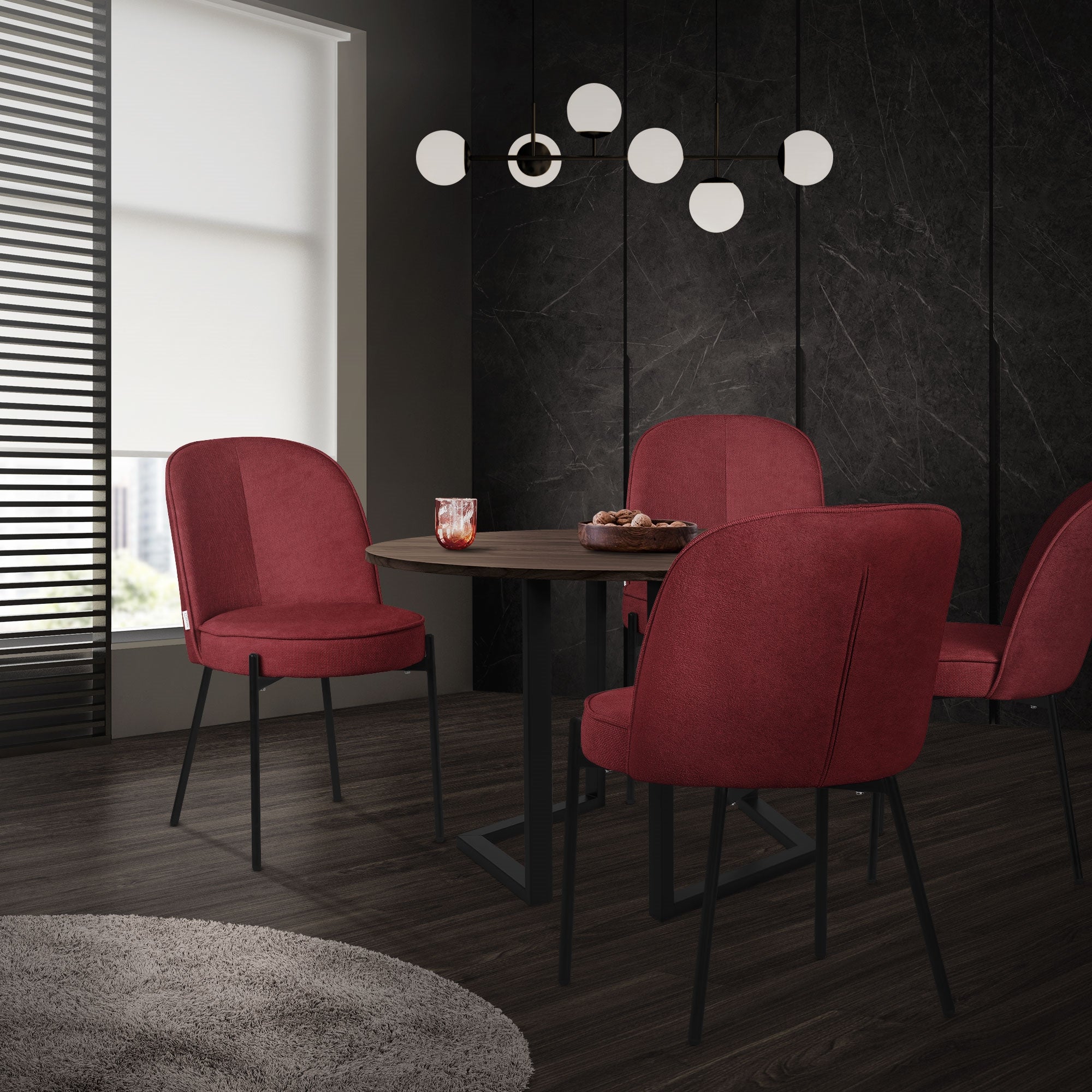 Une table ronde avec quatre chaises rouges dans une pièce moderne.