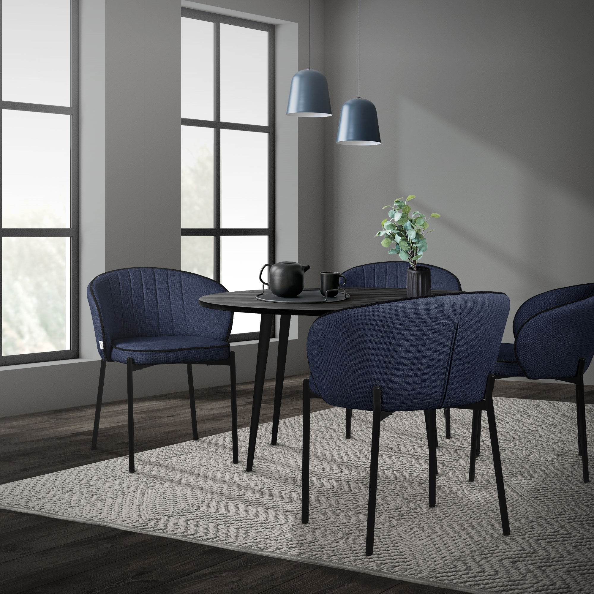 Esszimmer mit einem runden Tisch und vier blauen Stühlen.
