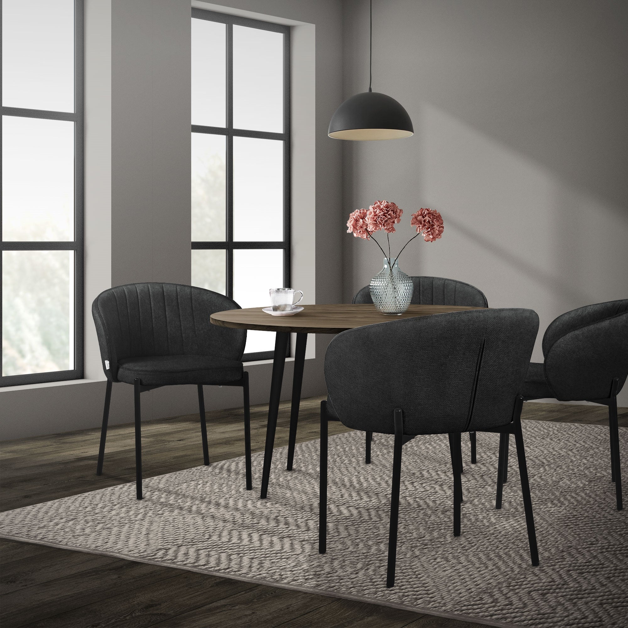 Esszimmer mit einem runden Tisch, vier Stühlen und einer Lampe.
