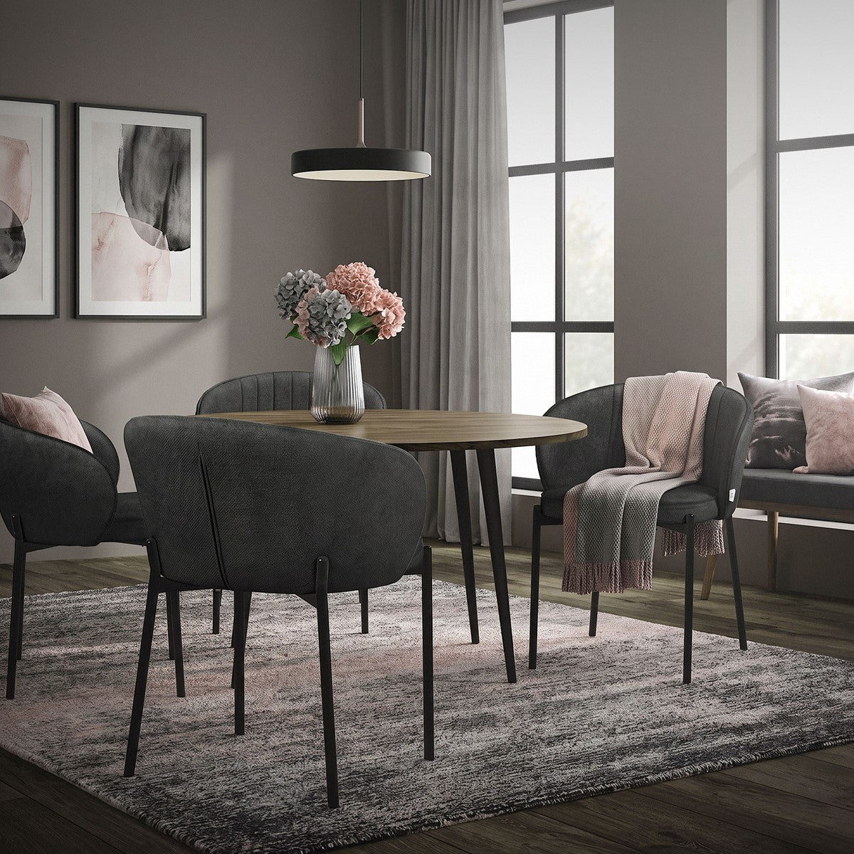 A dining room with a round table, chairs, and a vase of flowers.