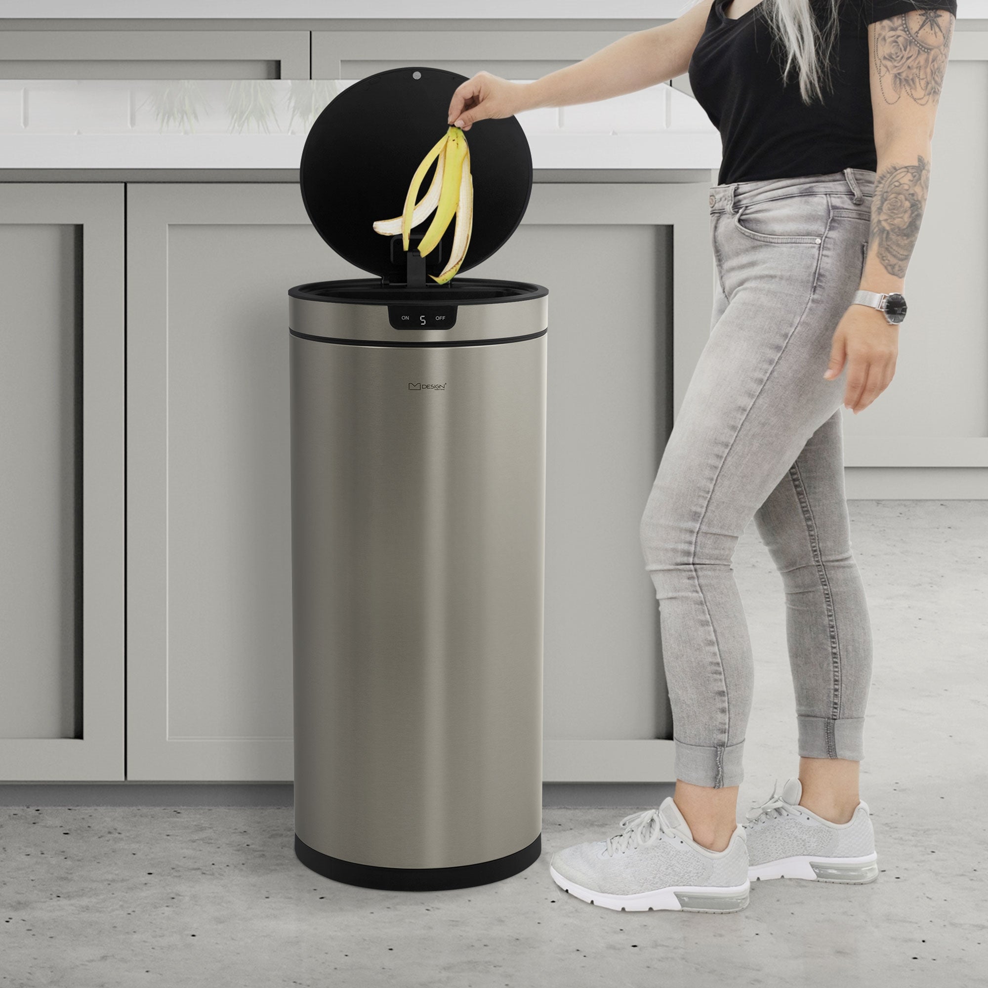 Donna con capelli lunghi che getta una banana in un cestino.