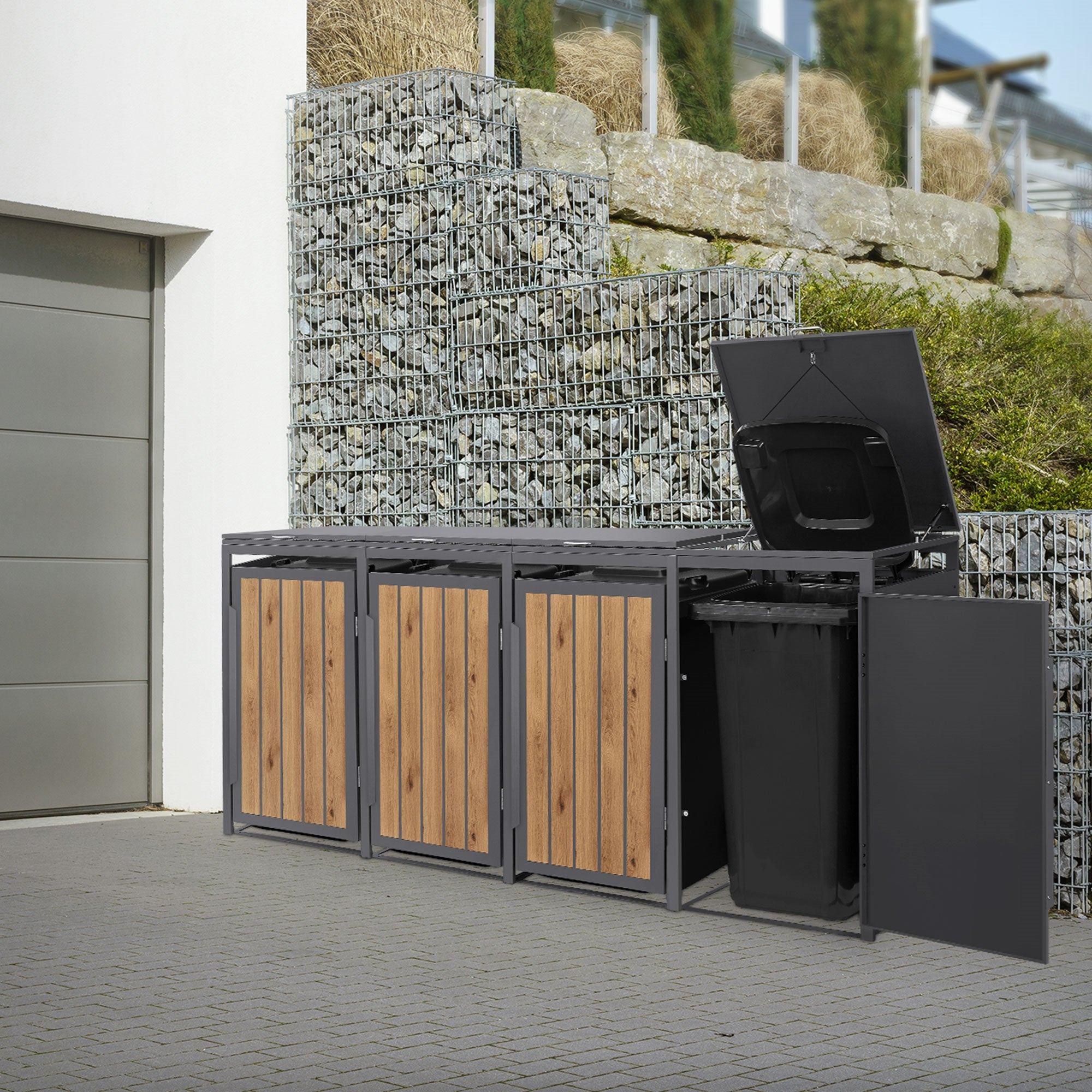Mülltonnenbox mit Holzfront und offenem Deckel, neben einer Mauer.