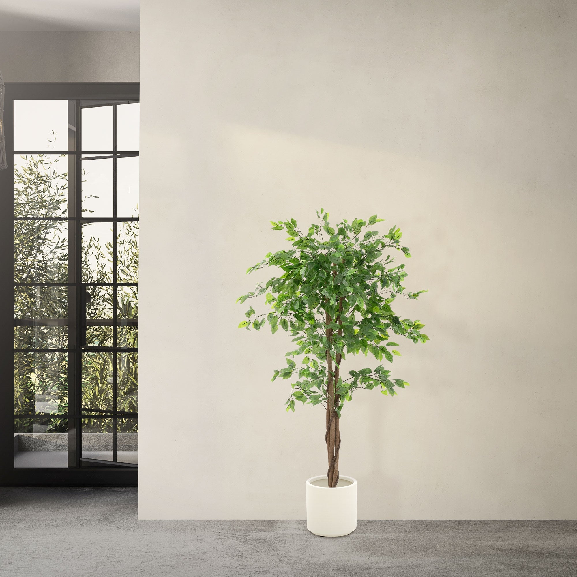 Pianta artificiale Ficus in un vaso bianco davanti a una parete.
