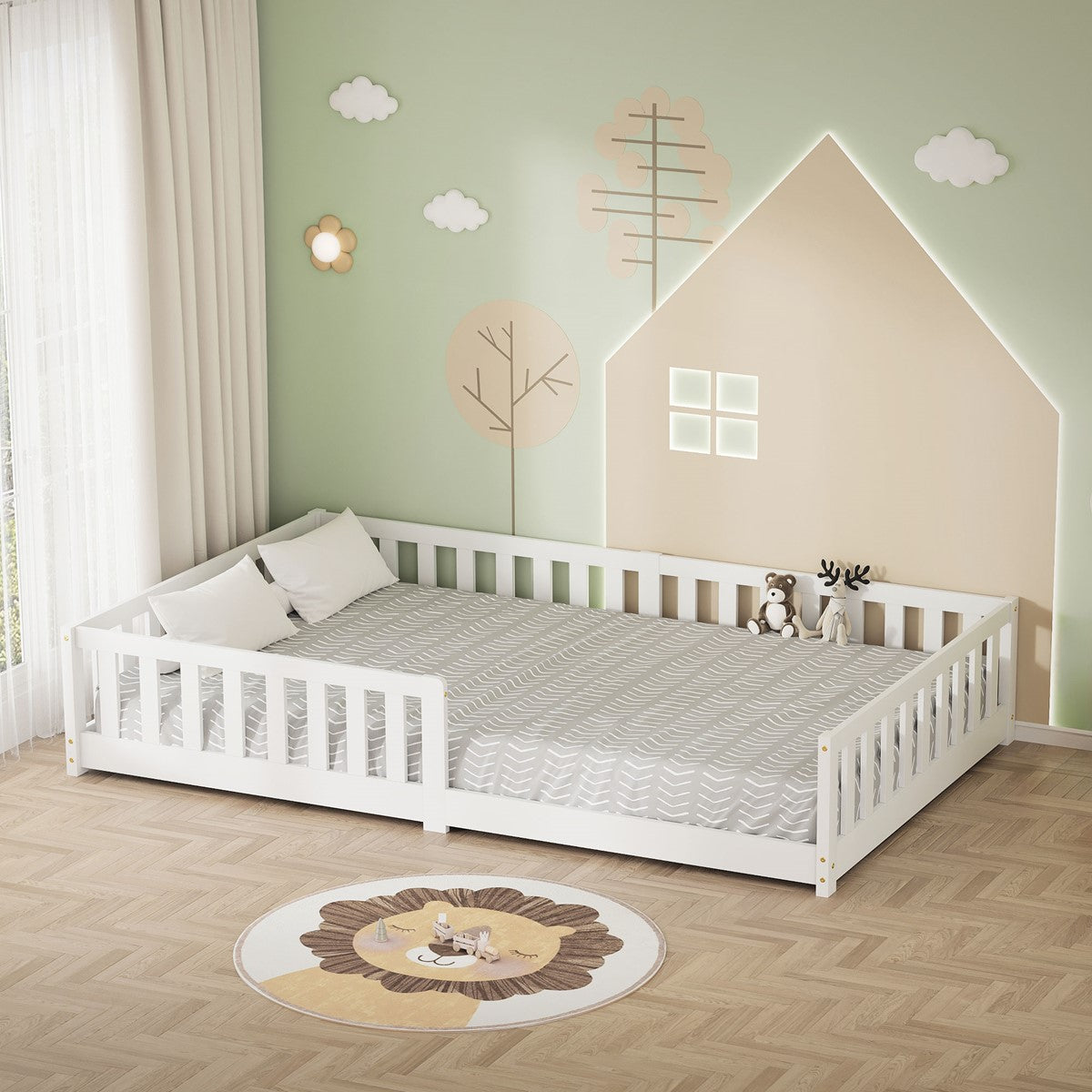 Letto basso per bambini bianco con biancheria da letto grigia e un cuscino, davanti a una parete verde menta decorata con case e alberi.