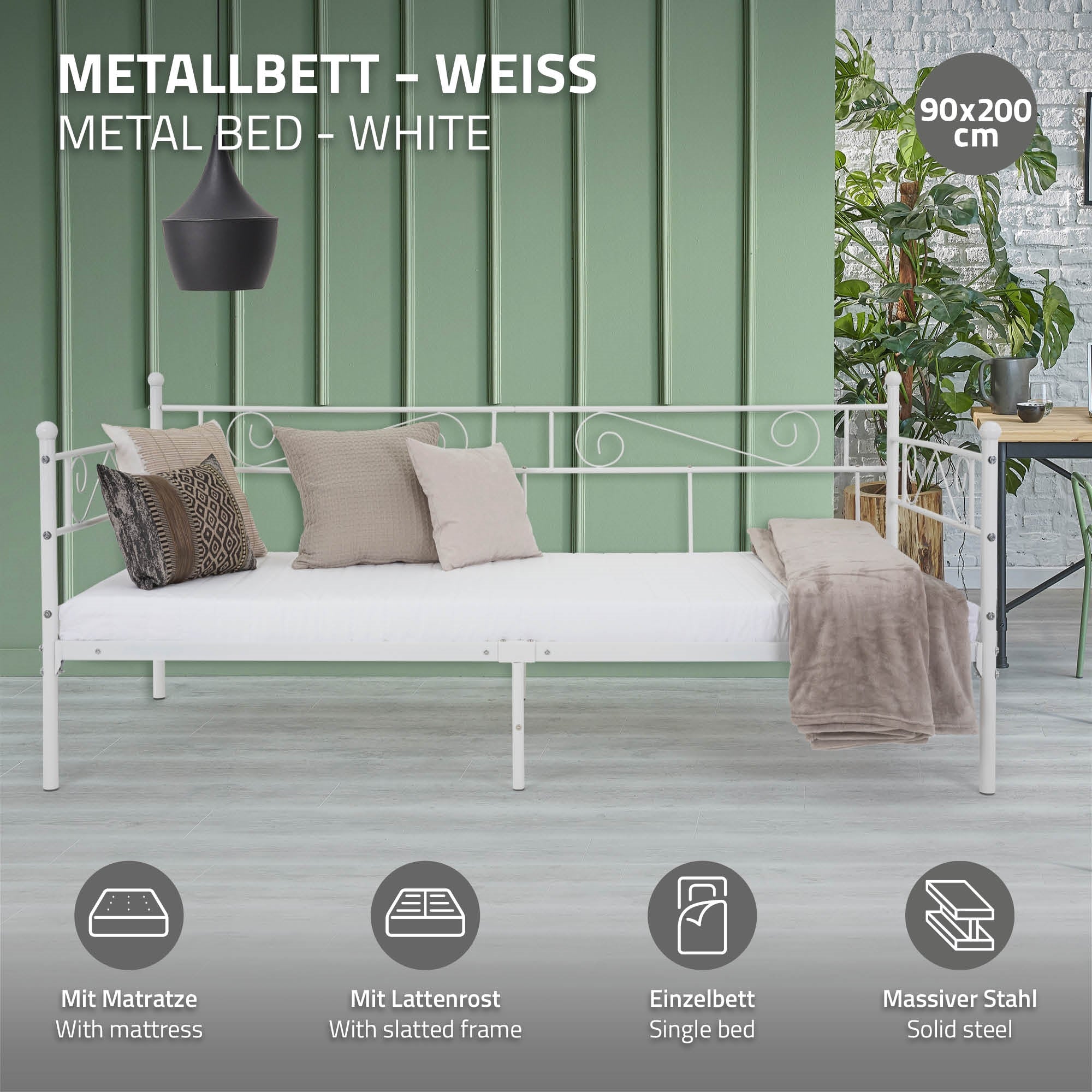 Weißes Metallbett mit Matratze und Kissen, vor grünem Hintergrund.