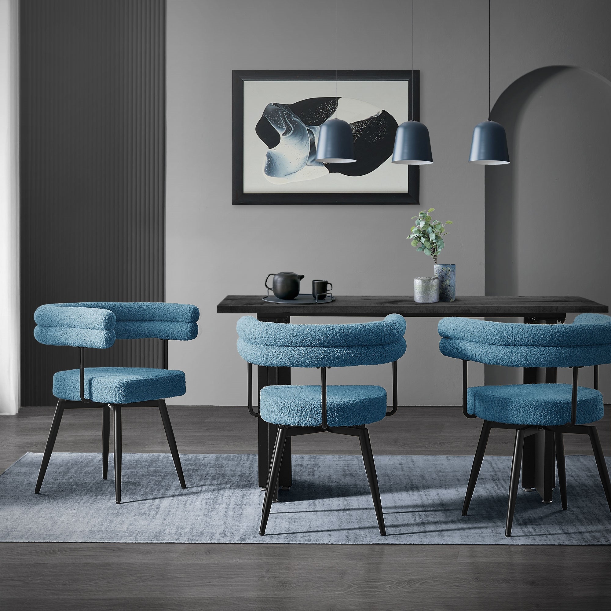 Esszimmer mit blauen Stühlen, schwarzem Tisch und dekorativem Bild an der Wand.
