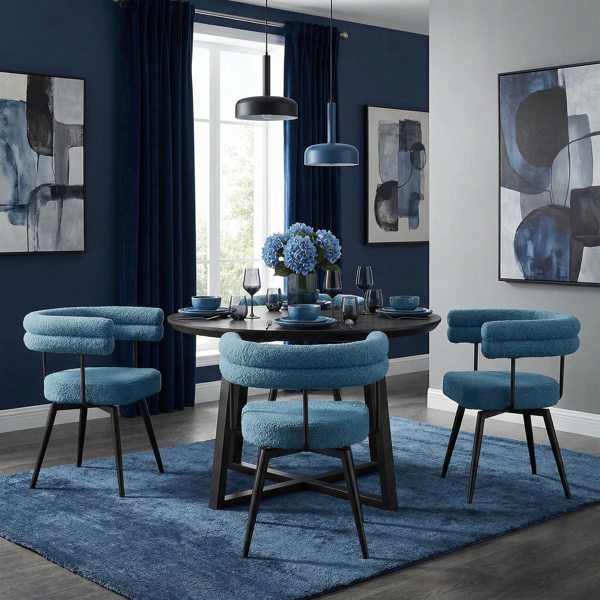 Esszimmer mit runden Tisch, vier blauen Stühlen und dekorativen Bildern an der Wand.