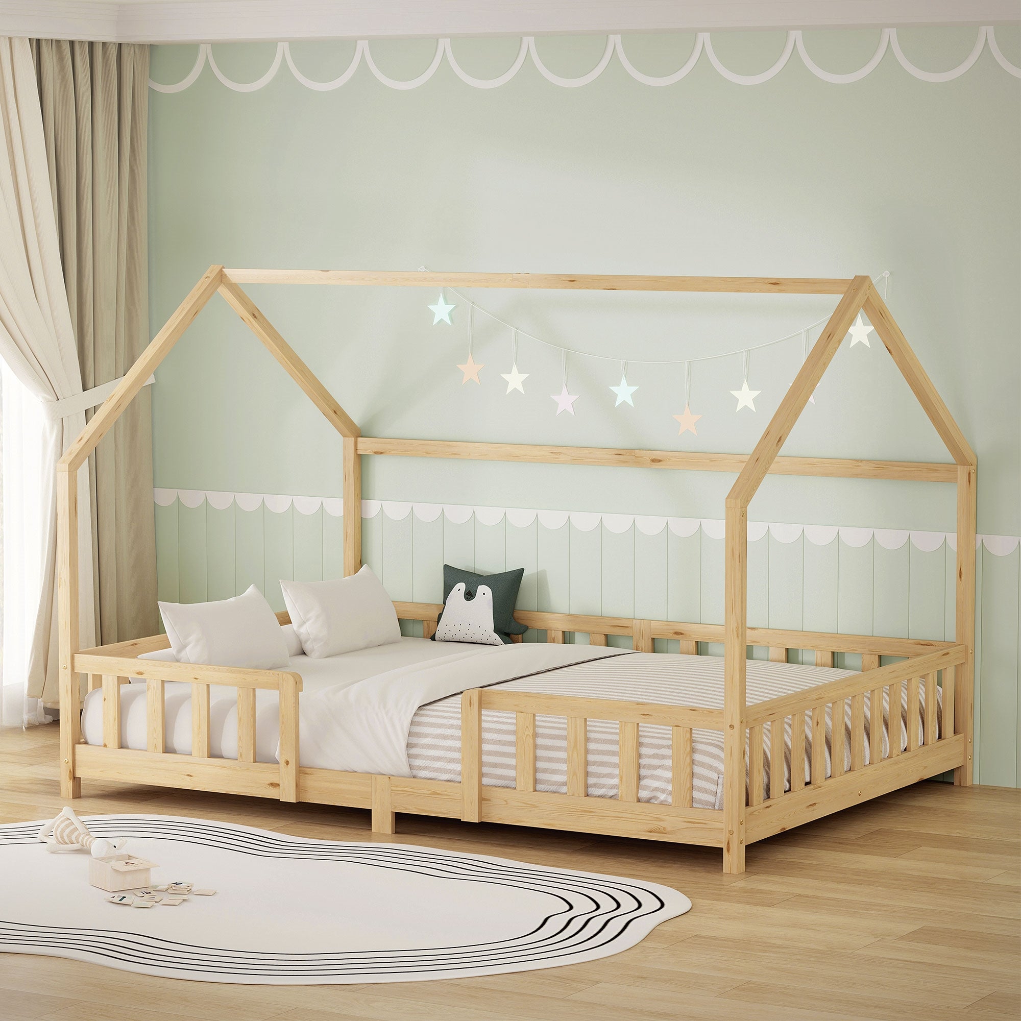 Letto in legno a forma di casa con due materassi e luci a forma di stella.