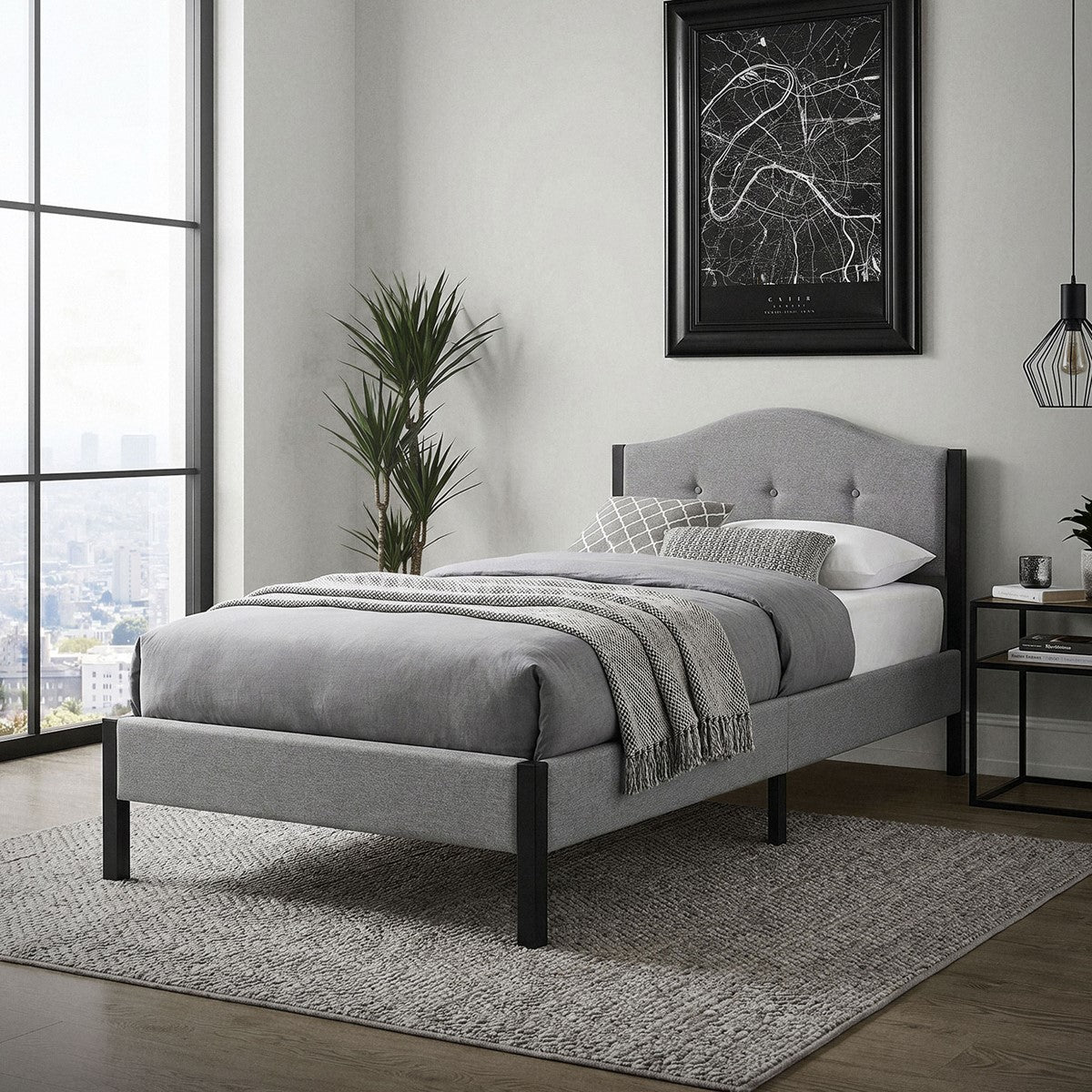 Gray upholstered bed in a modern room with a window and decorations.