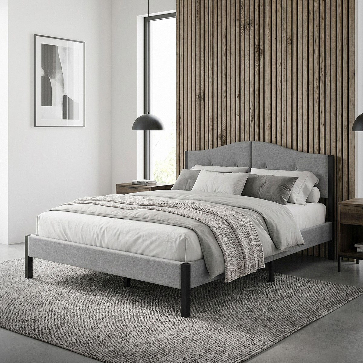 Bed in a modern room with wood paneling and gray pillows.