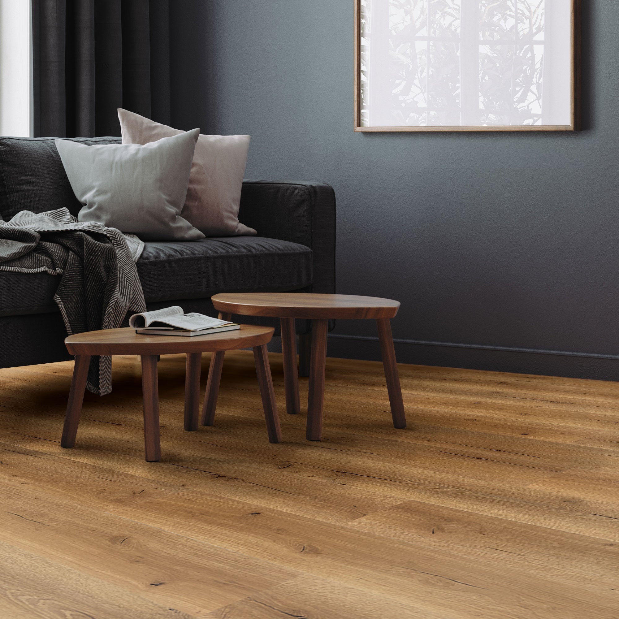 Sofa mit Kissen und zwei kleinen Tischen auf Holzboden im Wohnzimmer.