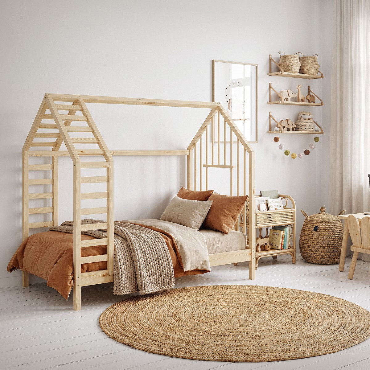 Holz-Kinderbett in Hausform mit Decke und Kissen, umgeben von Spielzeug.