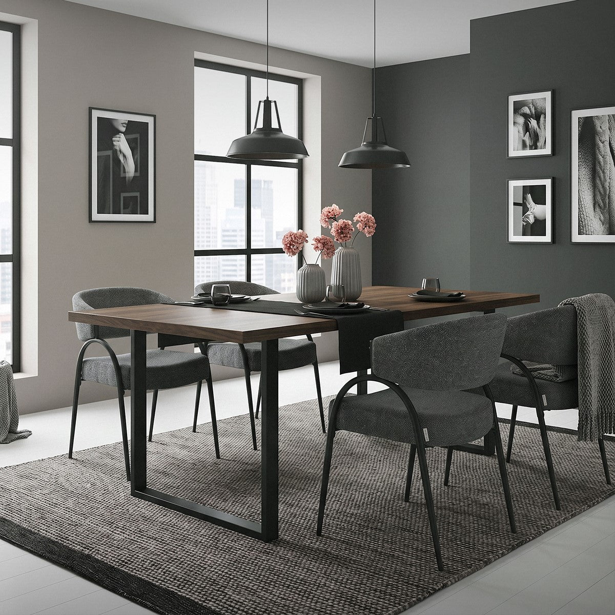 Esszimmer mit rechteckigem Holztisch, grauen Stühlen, zwei schwarzen Pendelleuchten und gerahmten Fotografien.