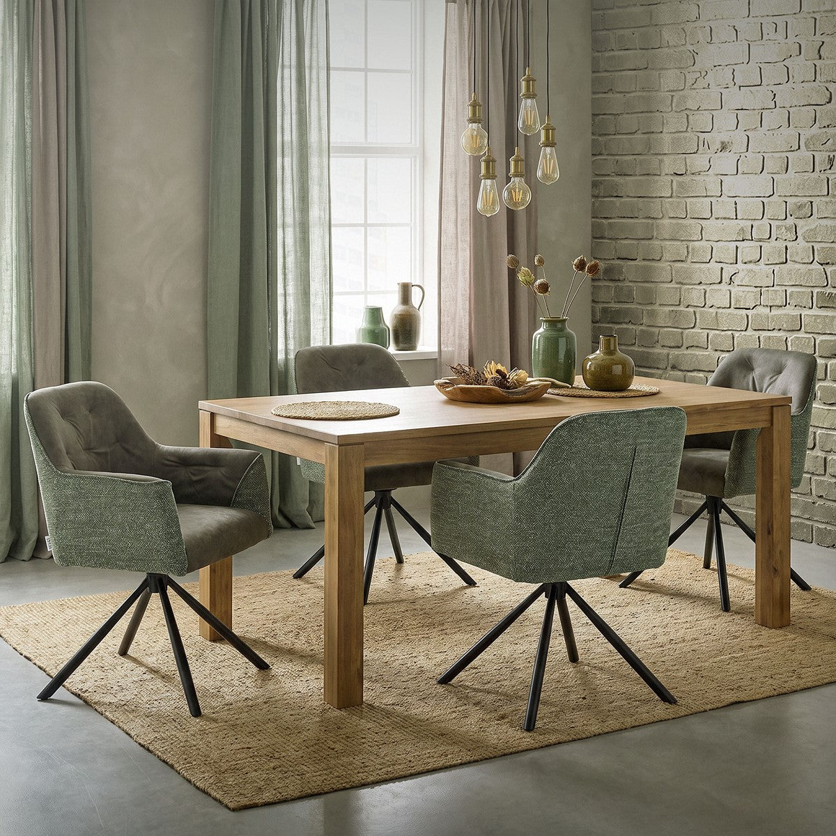 Cuatro sillas tapizadas verdes con bases giratorias negras están dispuestas alrededor de una mesa rectangular de madera.