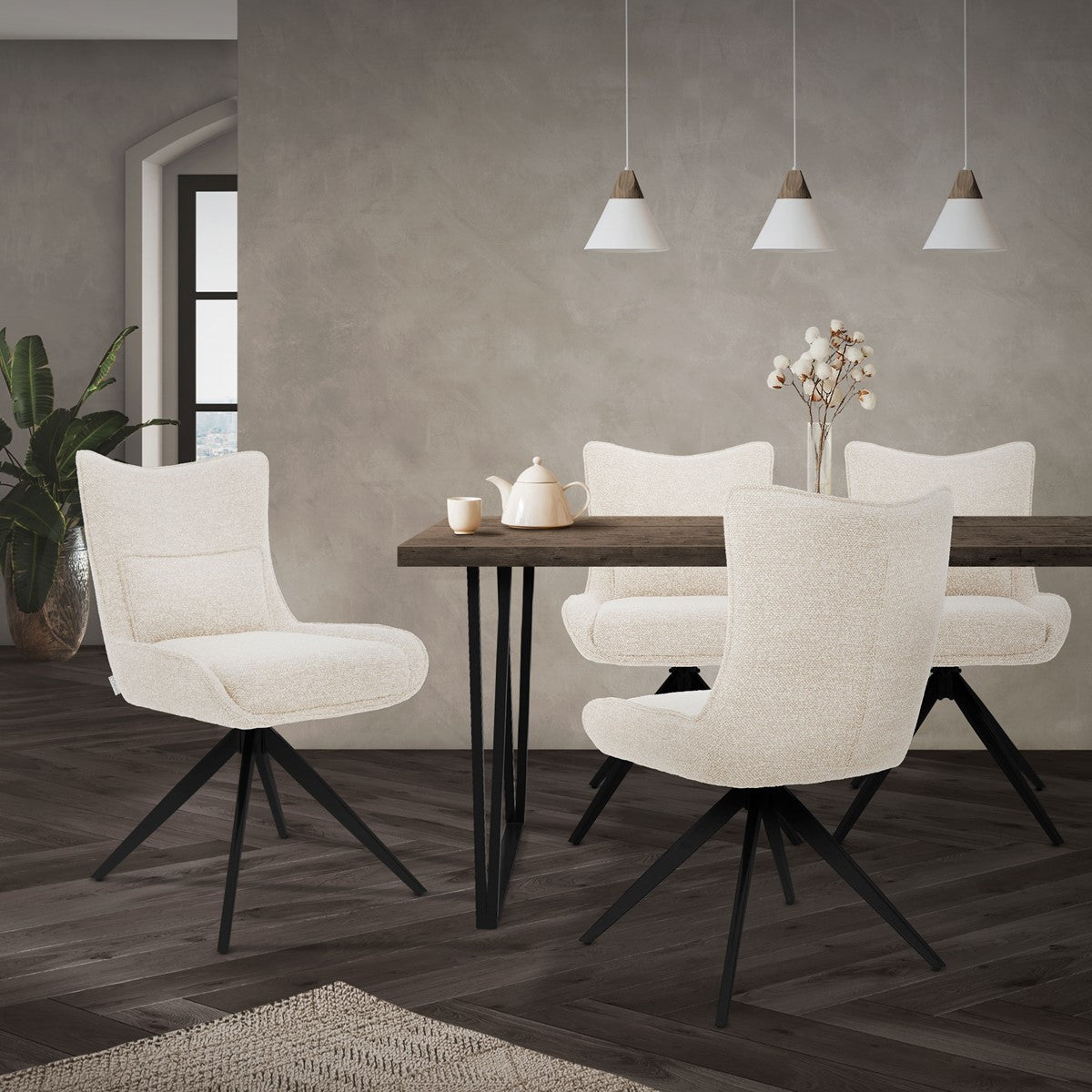 Quatre chaises rembourrées couleur crème avec des piètements pivotants noirs sont disposées autour d’une table à manger dans une pièce à vivre.