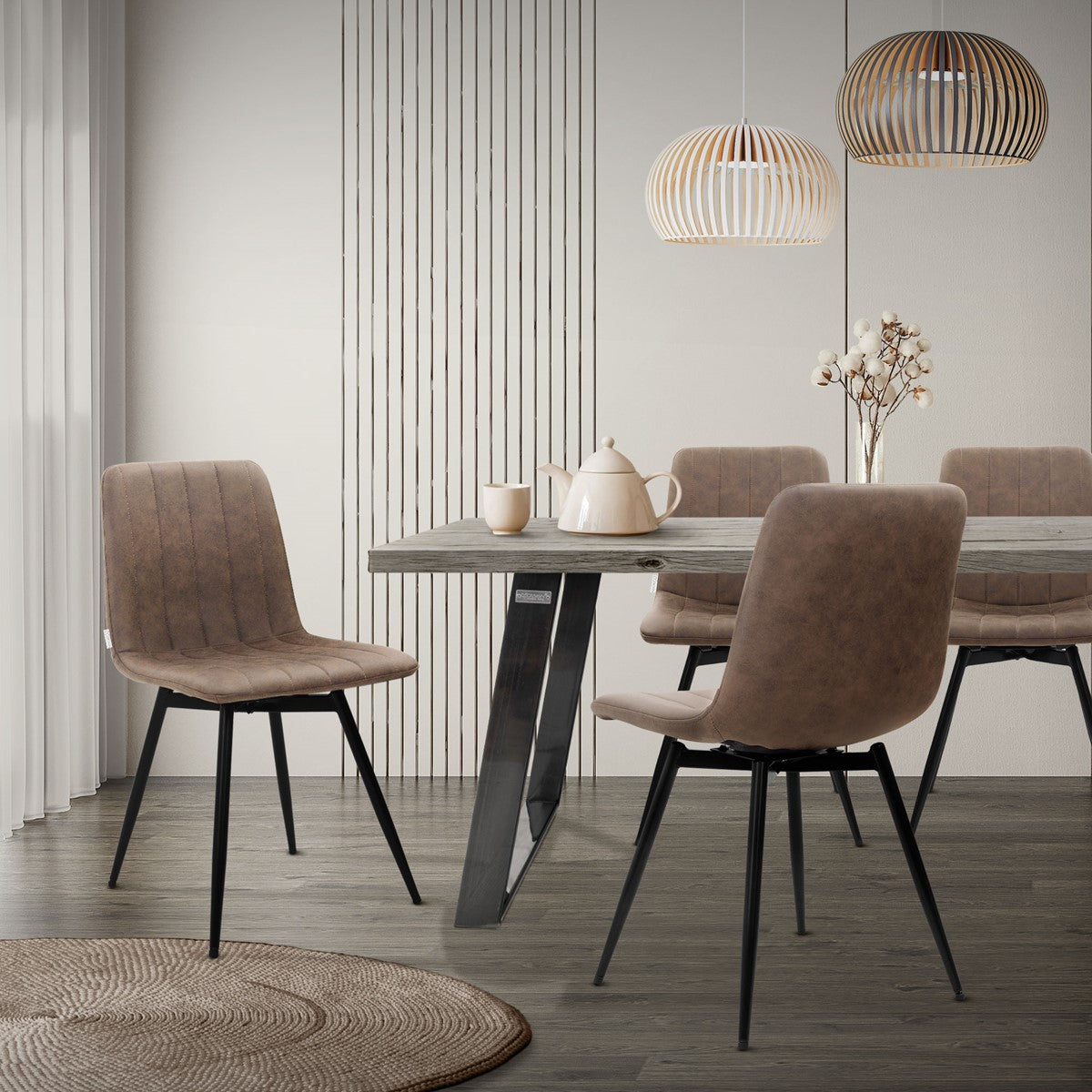 Bruine eetkamerstoelen aan een eettafel met twee hanglampen in een lichte ruimte.
