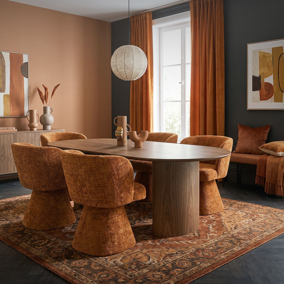 Esszimmer mit ovalem Holztisch, braunen Stühlen, Teppich, Bildern und Sitzbank am Fenster.
