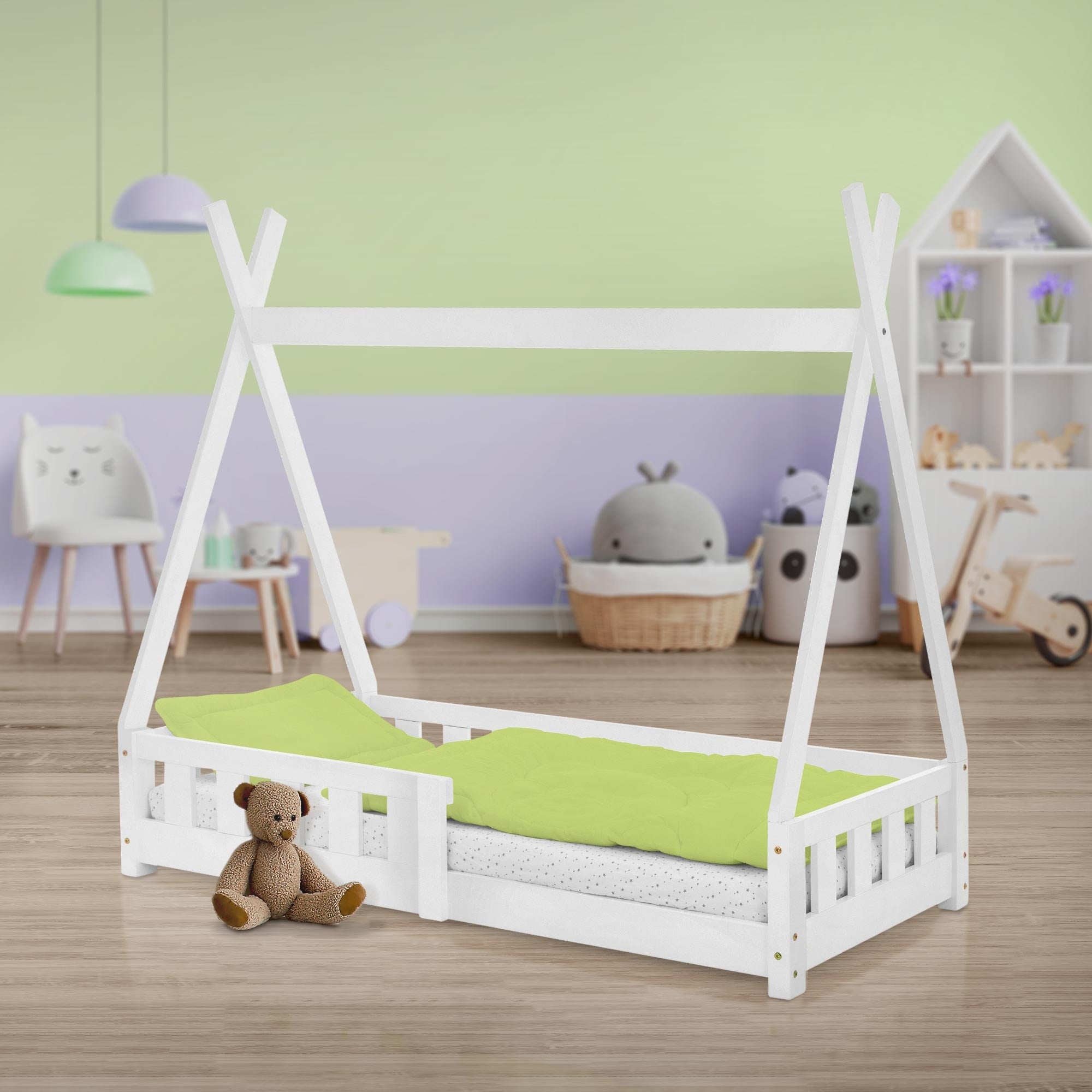 Weißes Bett im Kinderzimmer mit Spielzeug und grüner Bettwäsche.