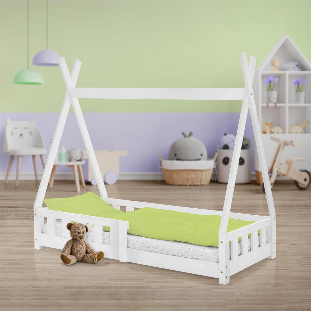 Uma cama infantil de madeira com roupa de cama verde e um peluche no chão.