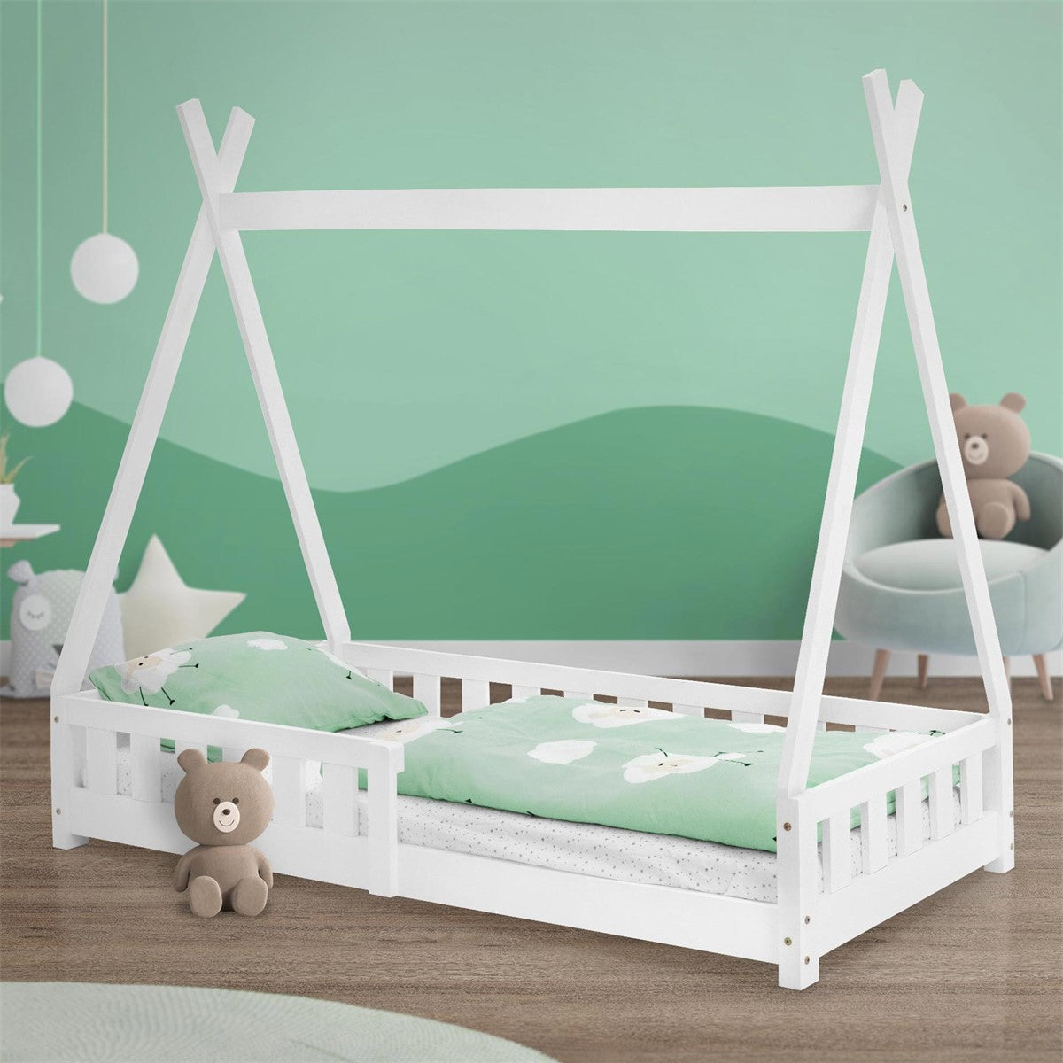 Lit avec du linge de lit vert et une peluche sur un sol en bois.