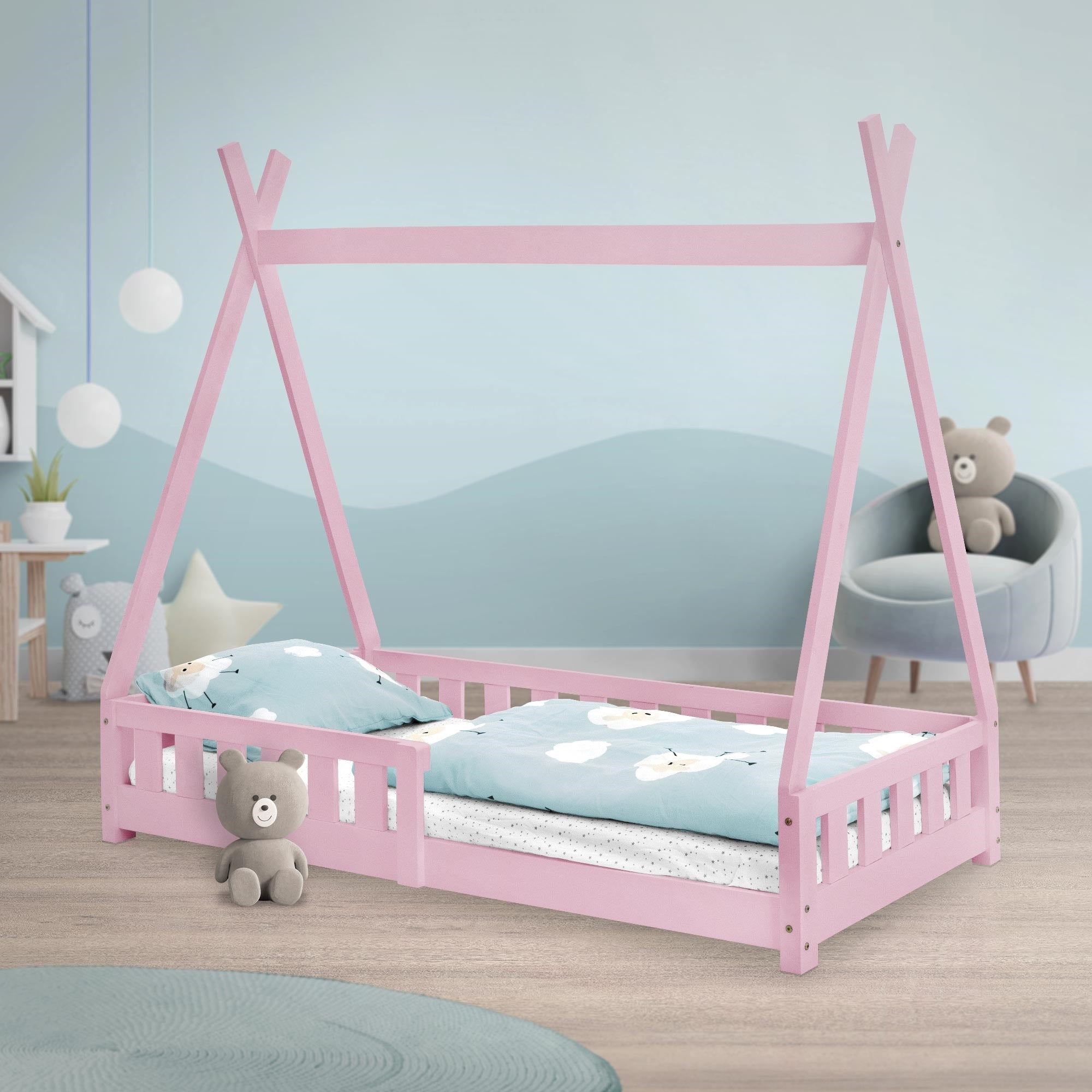 Een roze bed met kussens en dekens in een kinderkamer.