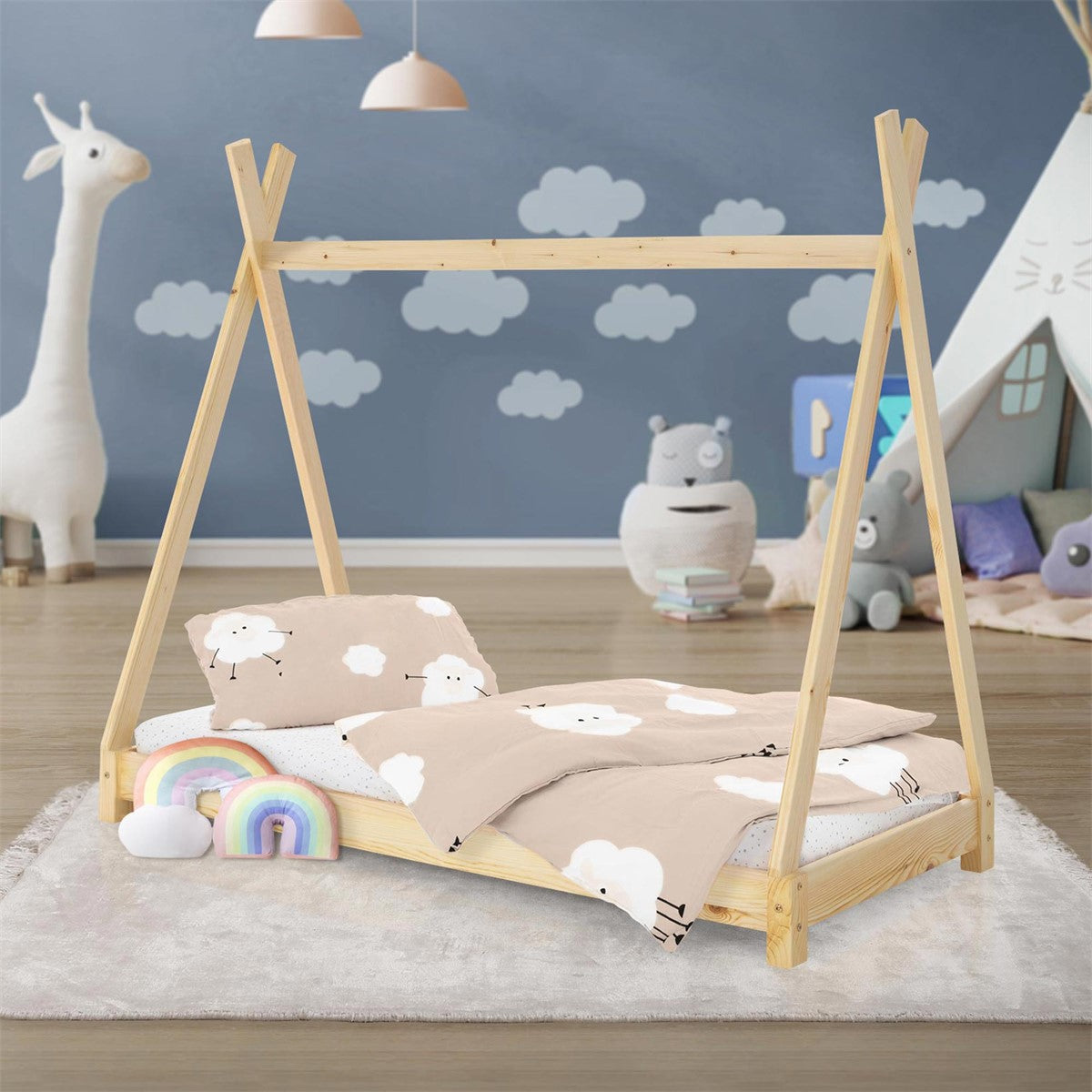 Un letto per bambini in stile tenda con motivo a nuvole, circondato da giocattoli e da una coperta accogliente.