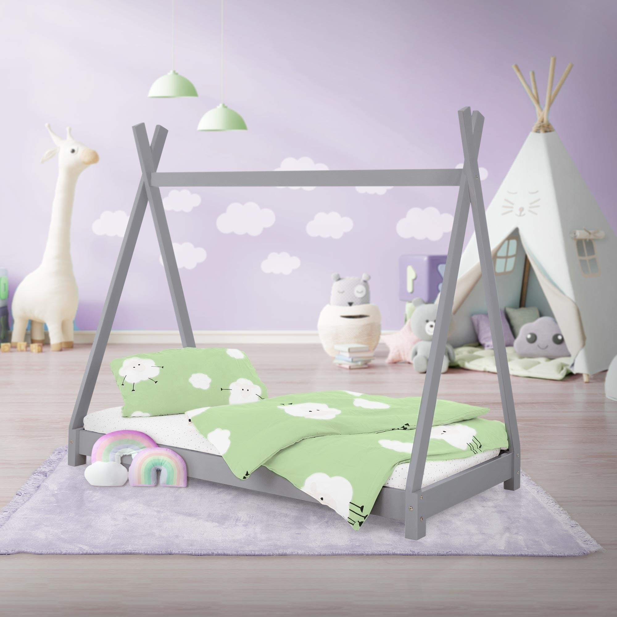 Ein Kinderbett im Zeltstil mit grauen Wänden und bunten Kissen.