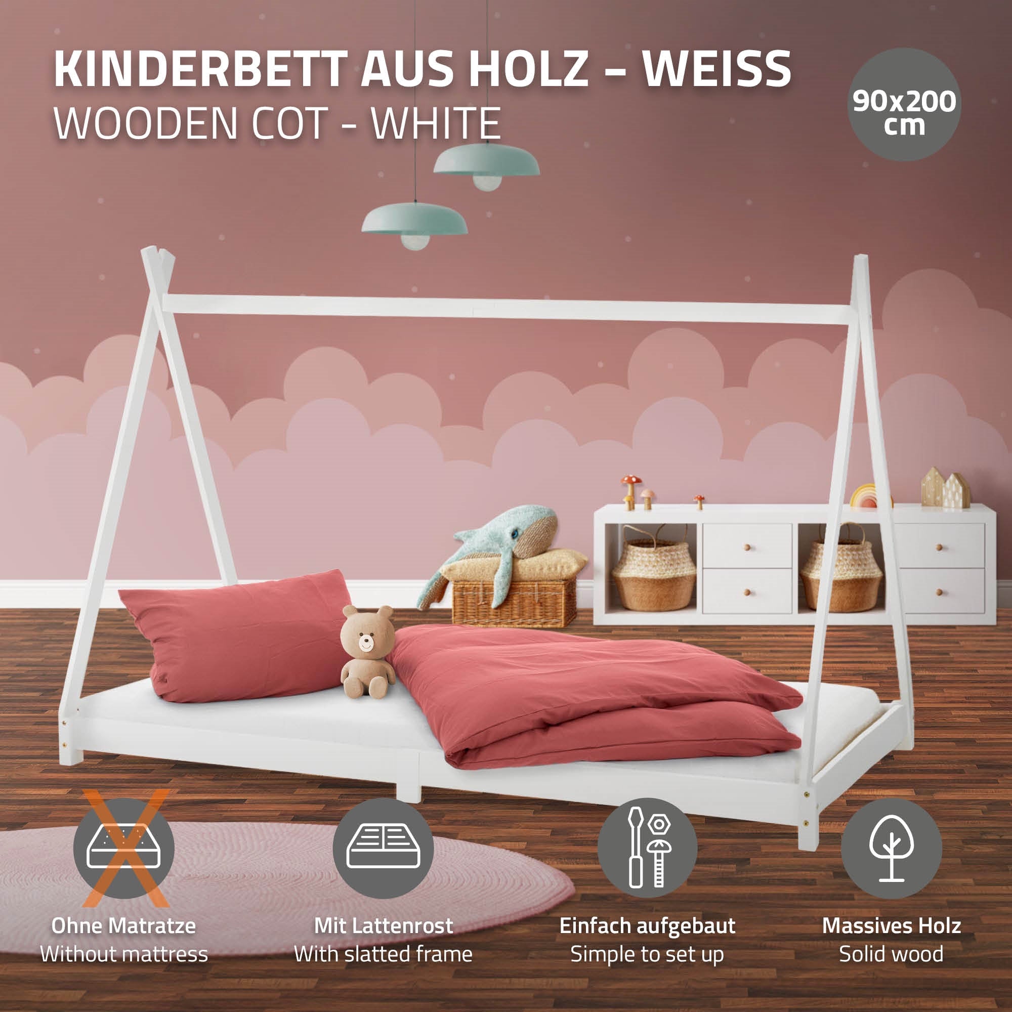 Weißes Kinderbett aus Holz mit rotem Kissen und Plüschspielzeug.