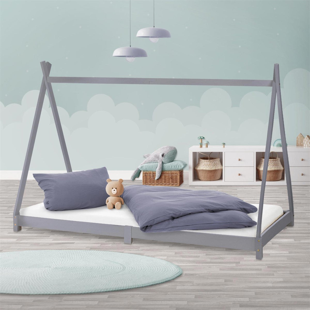 A Scandinavian-style bed with pillows and a toy bear.