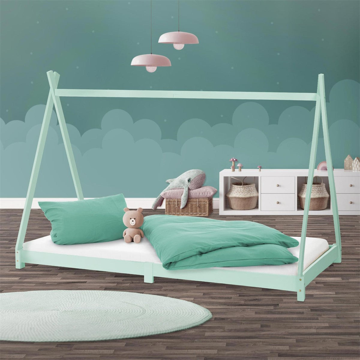 Mint-green bed frame with pillows and toys, shelves in the background.