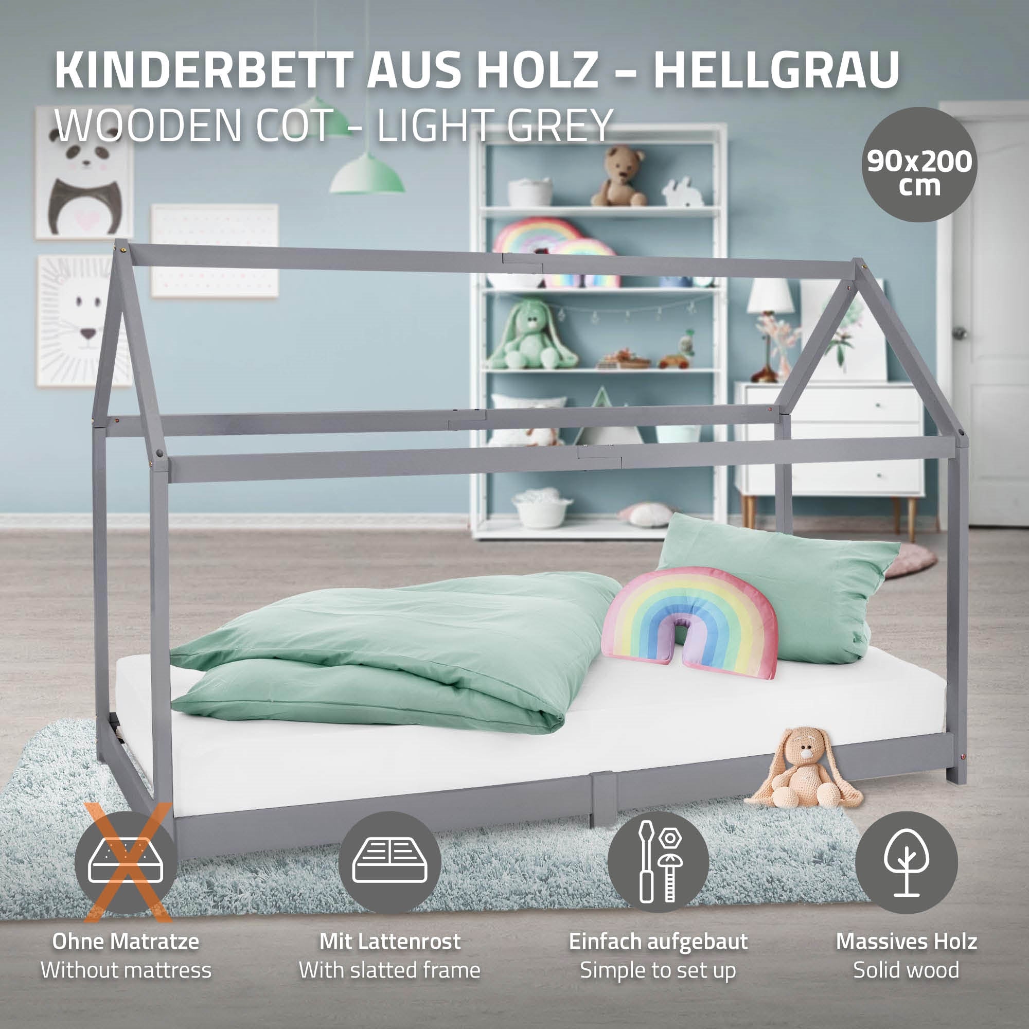 Holz-Kinderbett in hellgrau mit Kissen und Regenbogen-Dekoration.