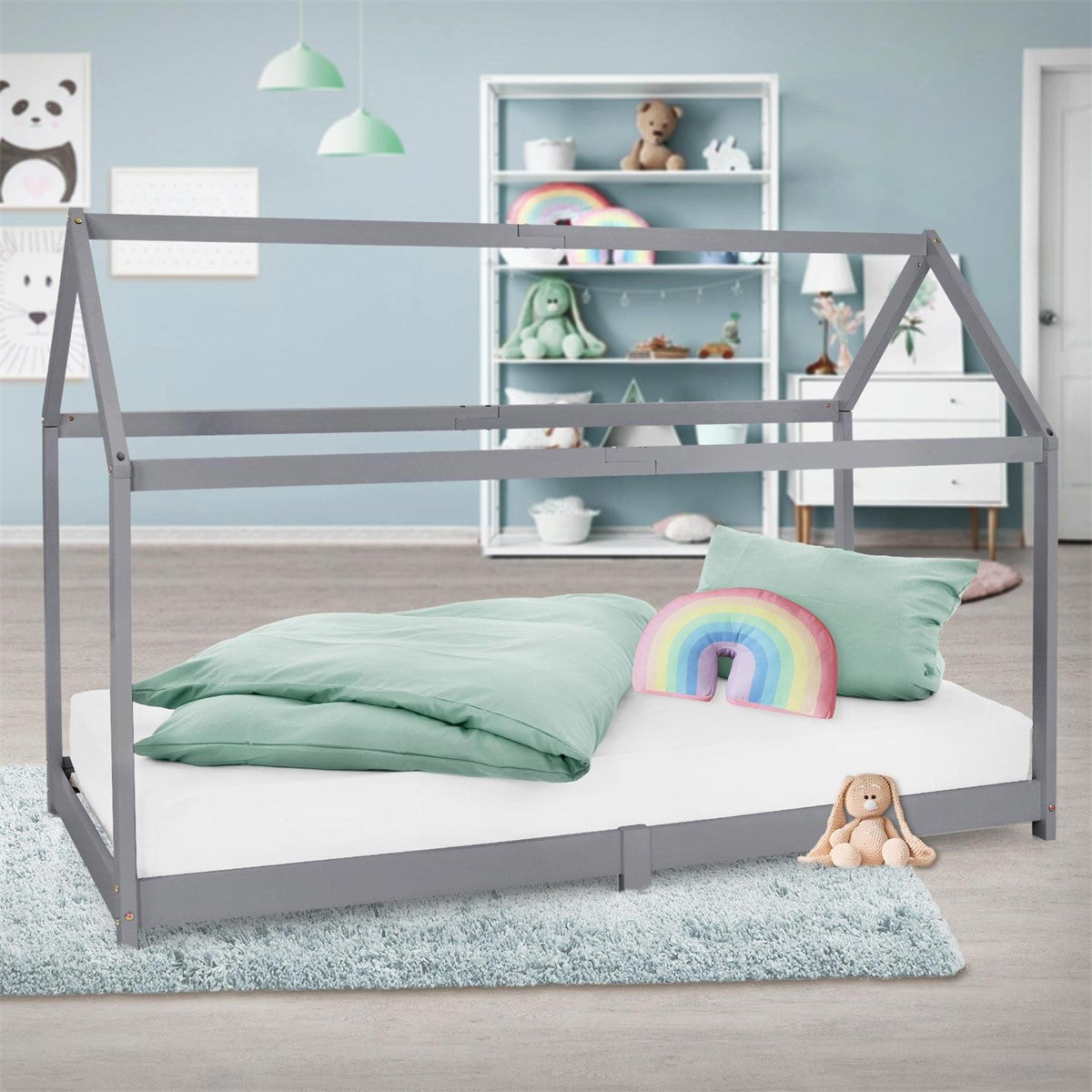A grey bed frame with pillows and a blanket on a rug.