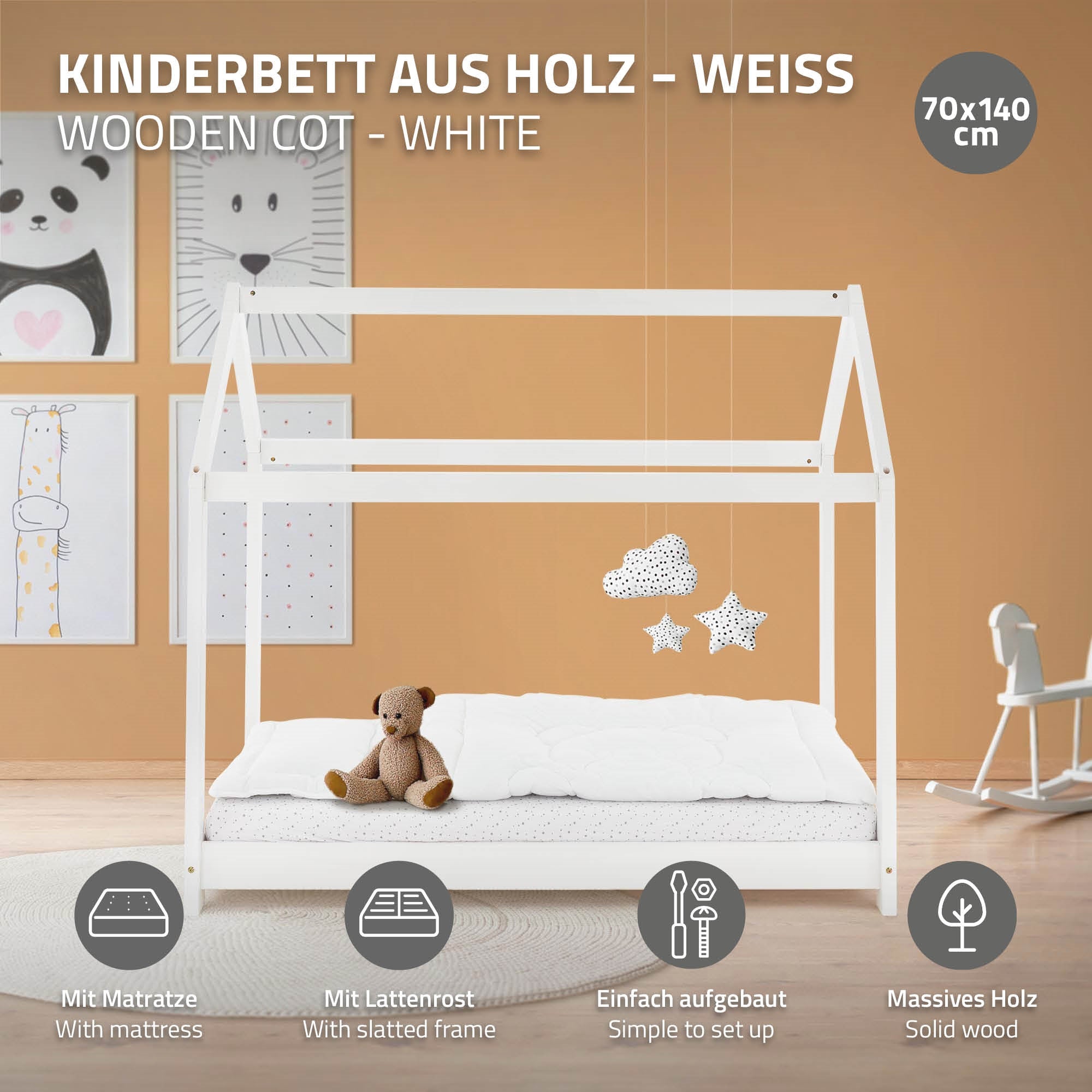 Een houten kinderbed met matras en lattenbodem in een kamer.