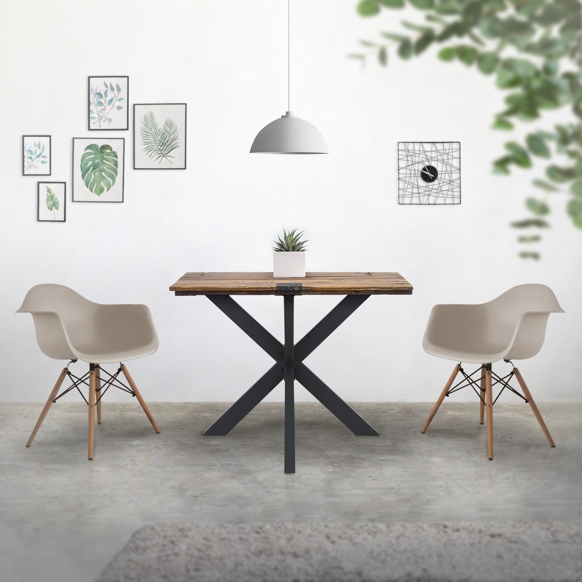 Essbereich mit Tisch, zwei Stühlen und Wandbildern.