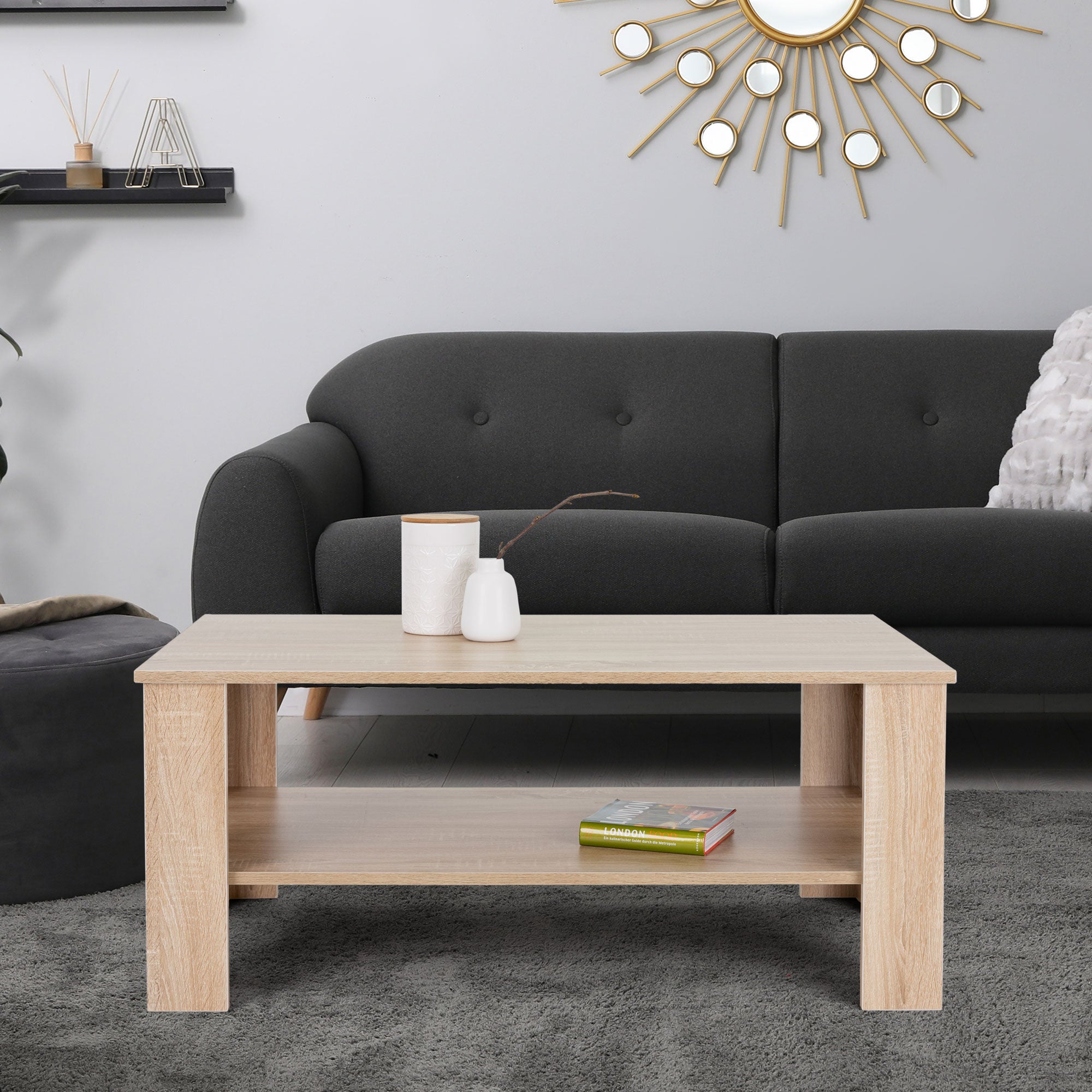 Holztisch vor einem grauen Sofa in einem modernen Wohnzimmer.