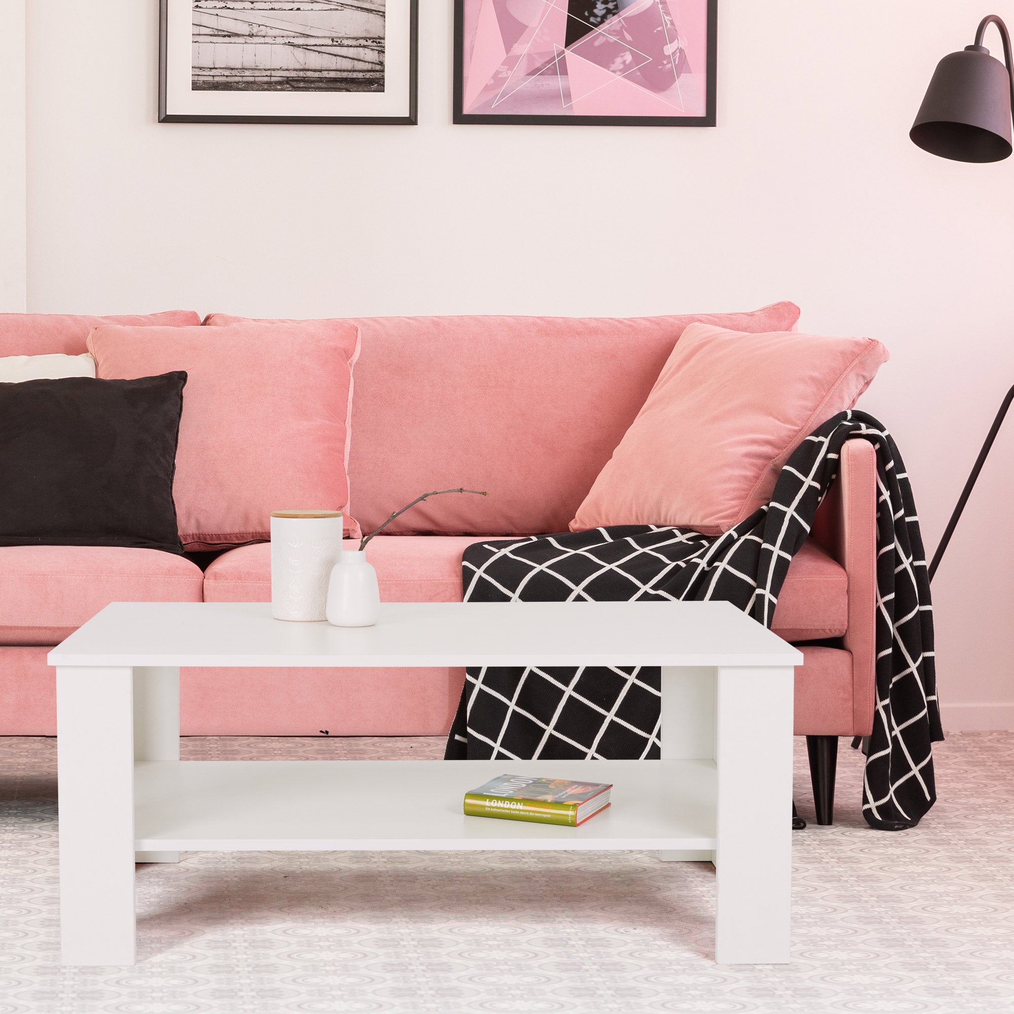 Sofá rosa con cojines y una mesa blanca en la sala de estar.
