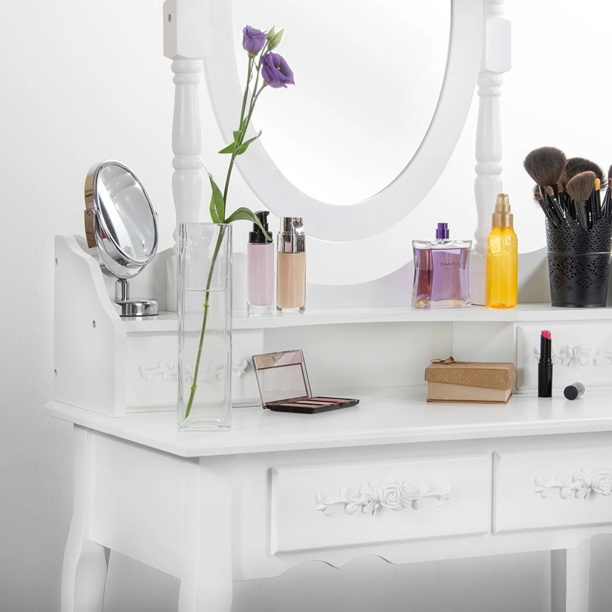 White dressing table with cosmetic bottles and a mirror.