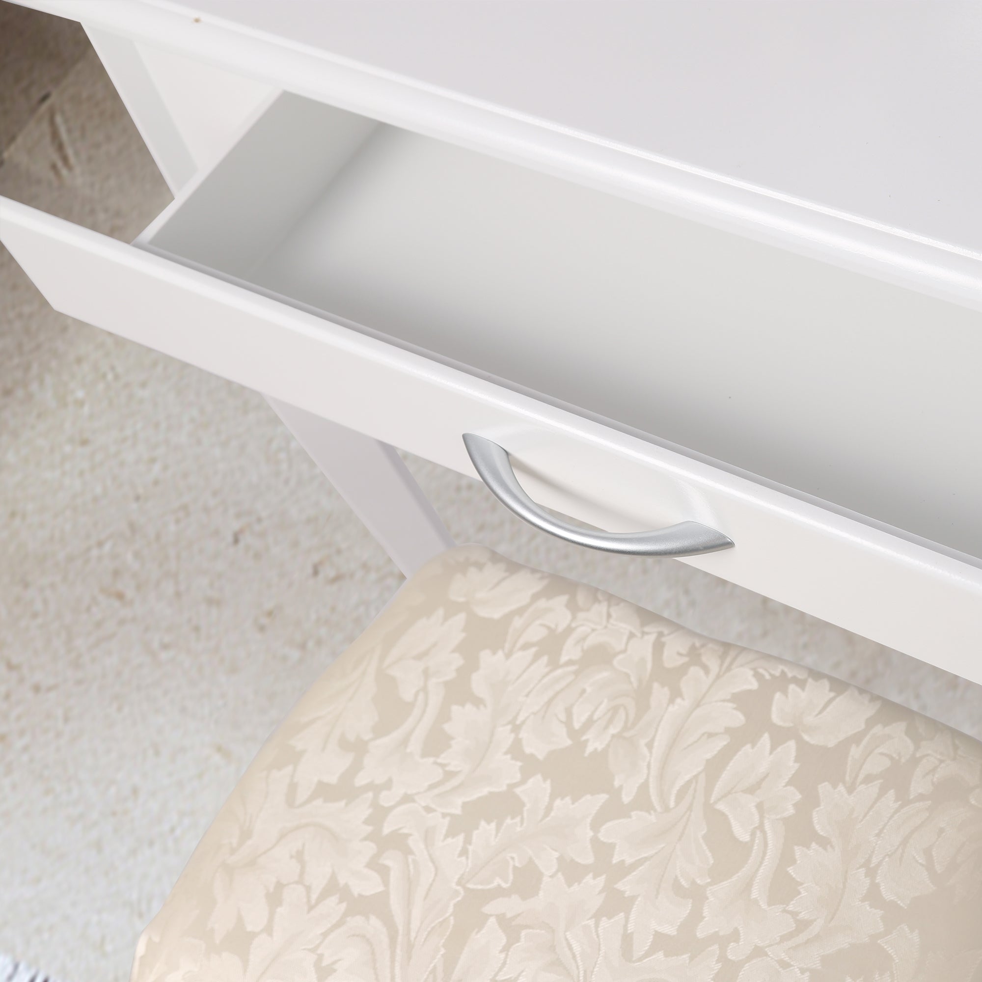 Open lade van een make-up tafel met een gestoffeerde kruk.