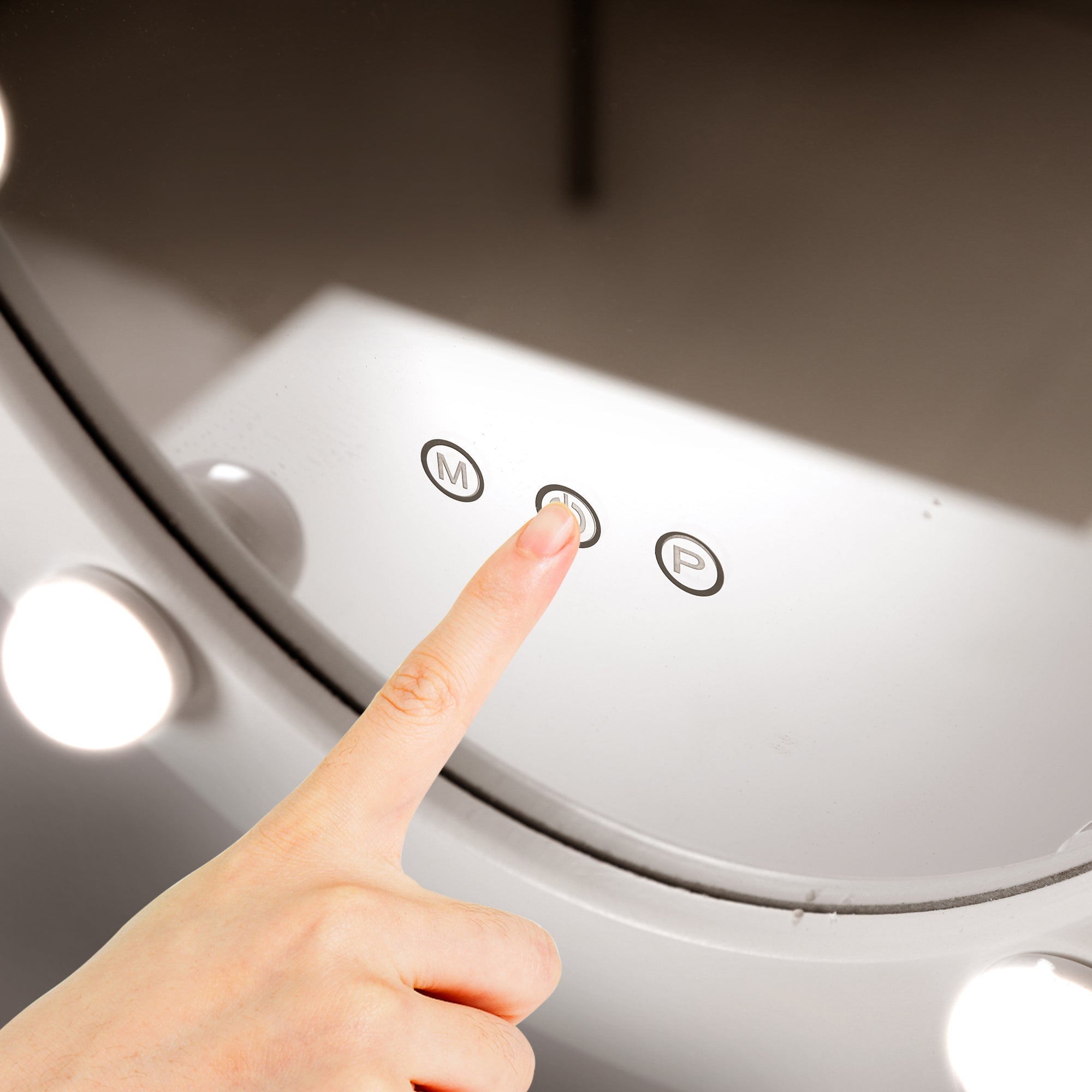 Close-up of a mirror with a finger touching a button.