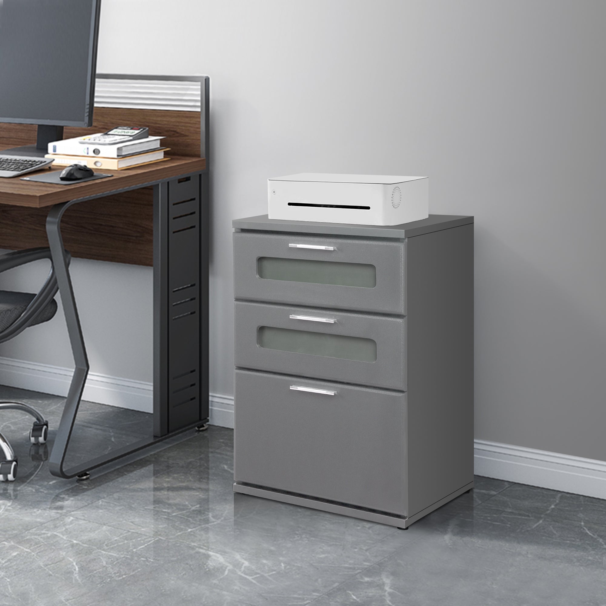 Gray cabinet with three drawers and a white device on top.