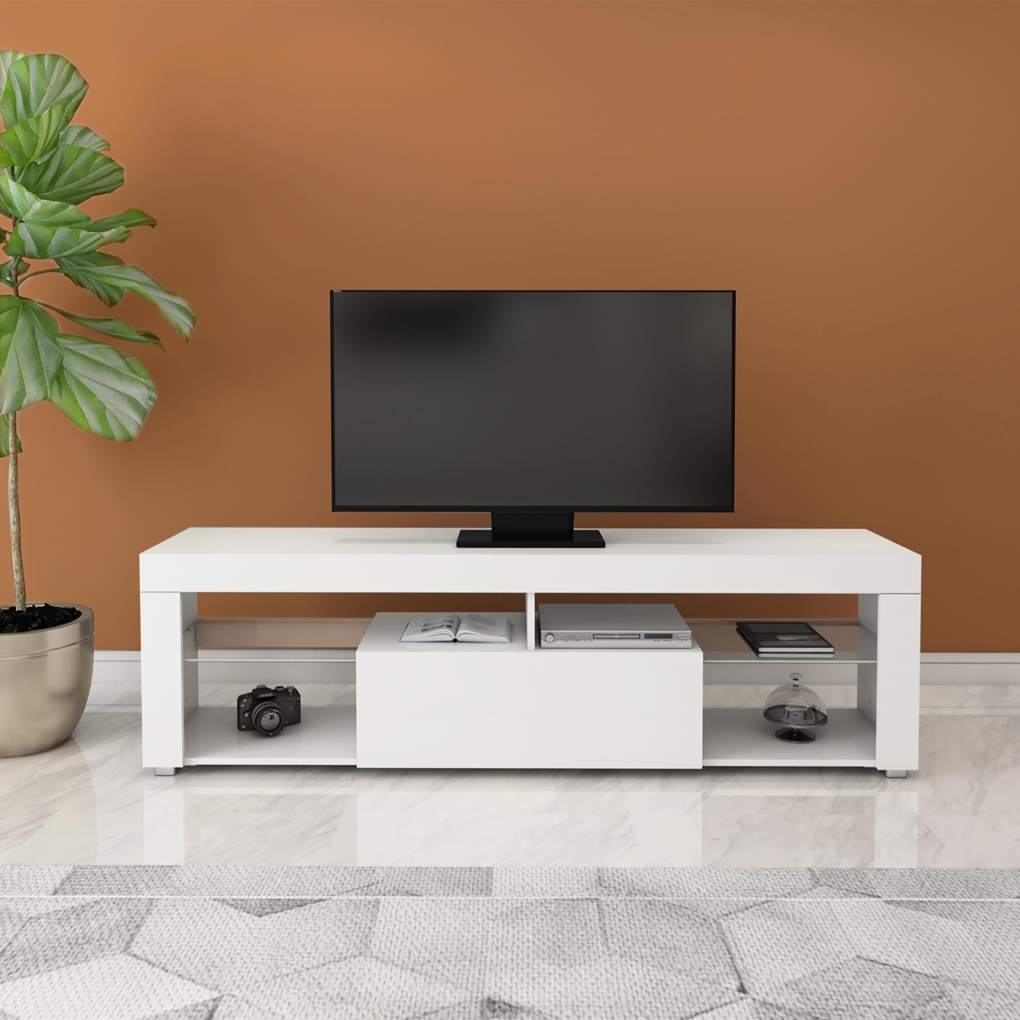 Weißes TV-Möbel mit Fernseher und Pflanzen im Hintergrund.
