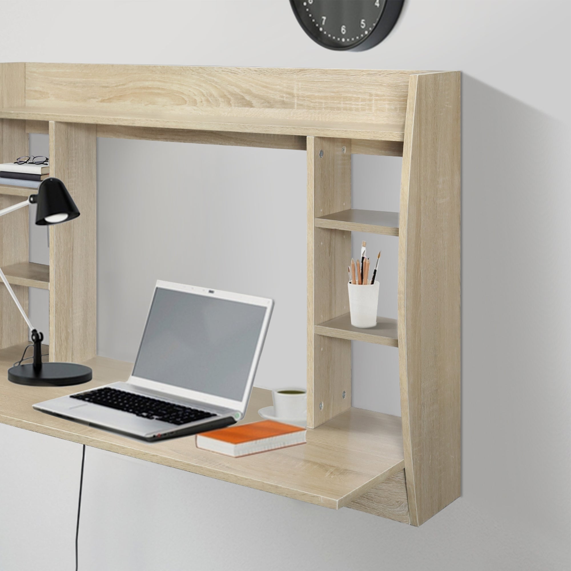 Træ skrivebord i lys farve, med laptop og skrivebordslampe.